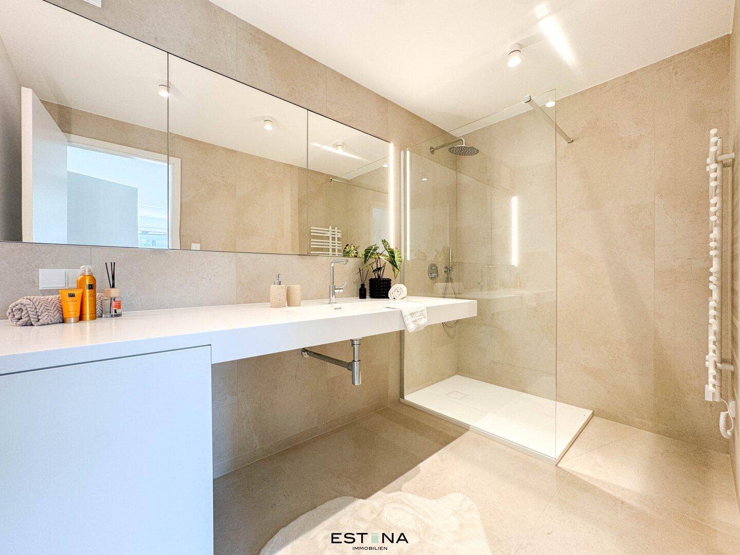 Modernes Badezimmer mit begehbarer Dusche, Doppelwaschbecken und großem Spiegelschrank.