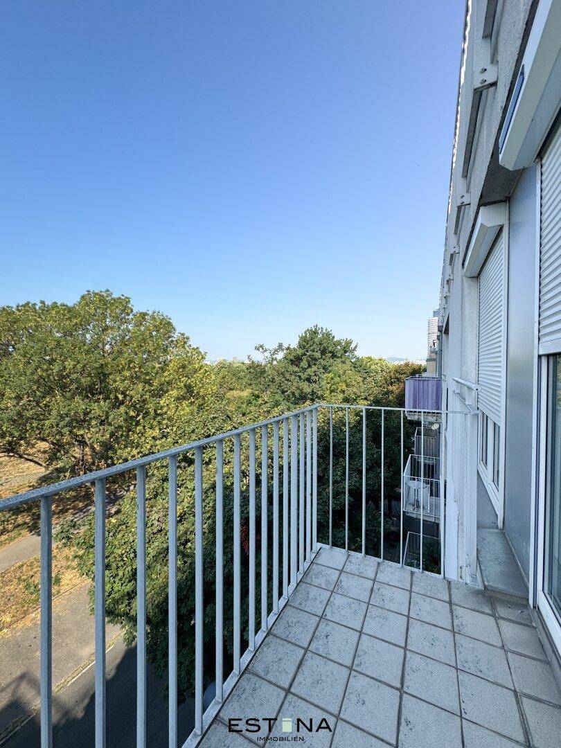 Kleiner Balkon mit Fliesenboden und Blick ins Grüne, ideal für entspannte Momente im Freien.