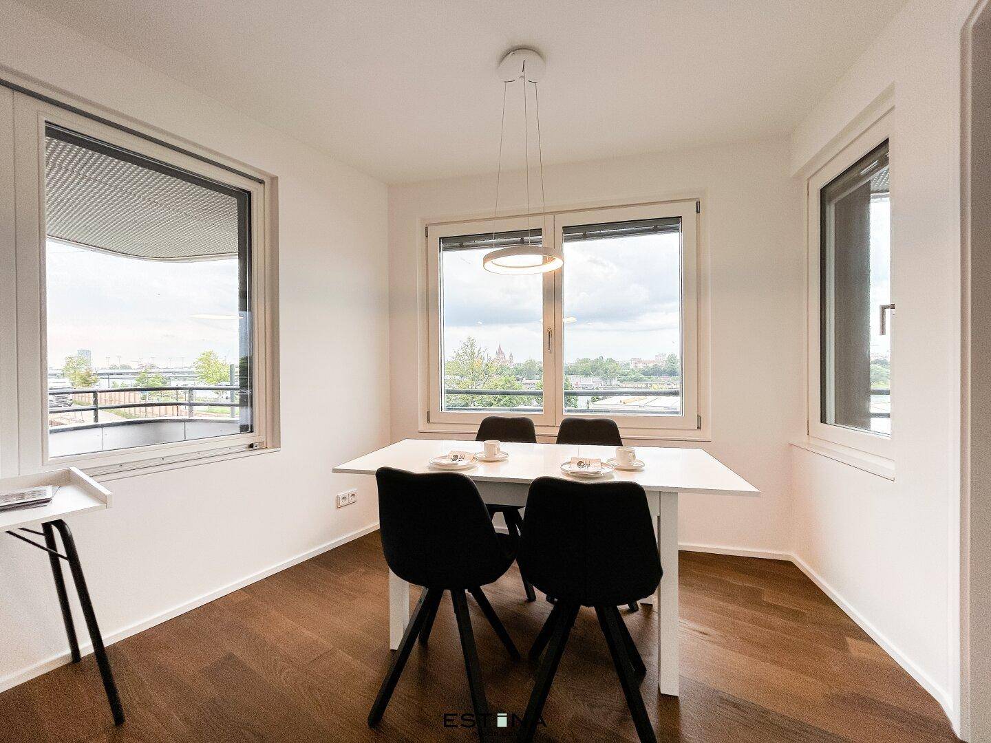 Heller Essbereich mit modernem Tisch und Stühlen, Holzboden und weitem Ausblick.