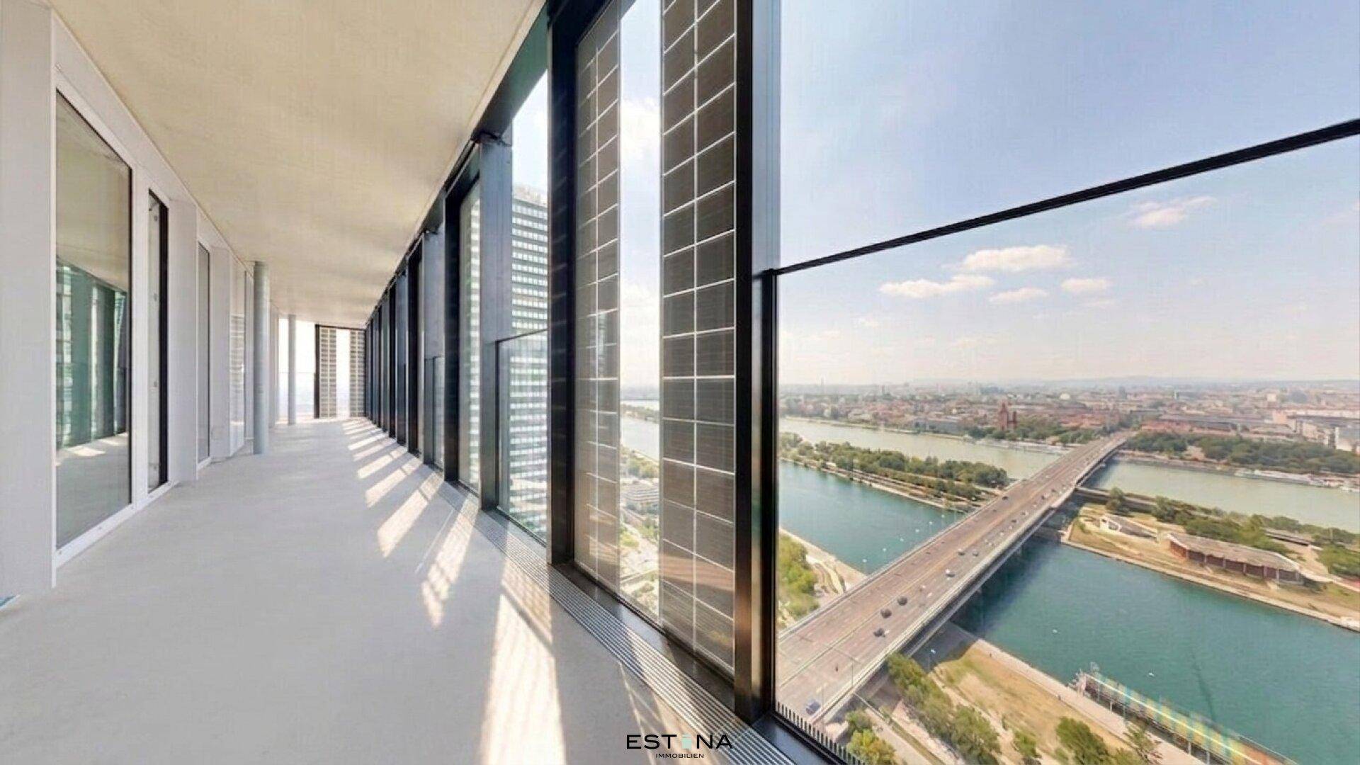 Moderner Flur mit raumhohen Fenstern, die einen weiten Blick über die Stadt und den Fluss bieten.