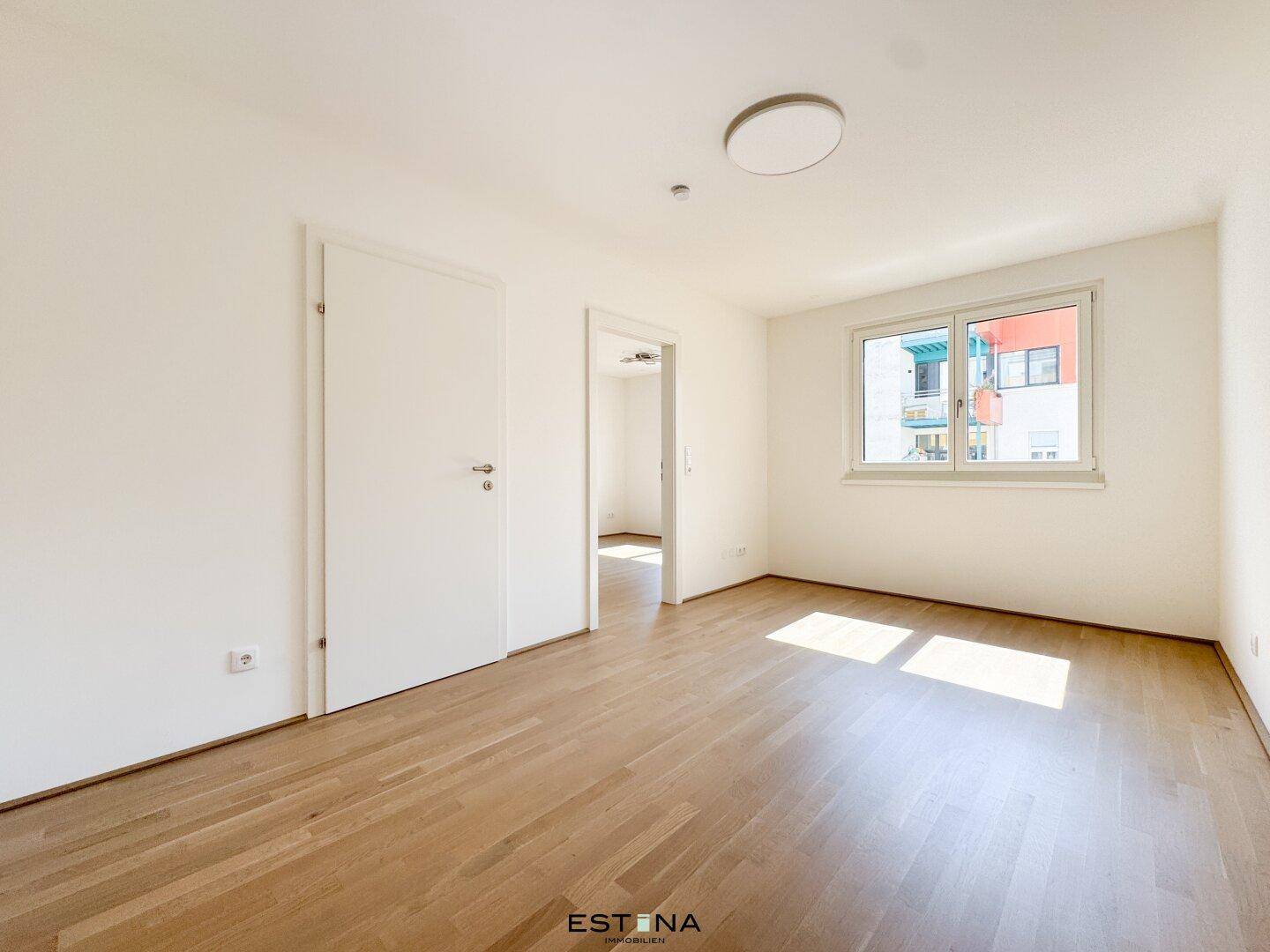 Helles Zimmer mit Parkettboden und Fenster, ideal als Schlaf- oder Arbeitszimmer.
