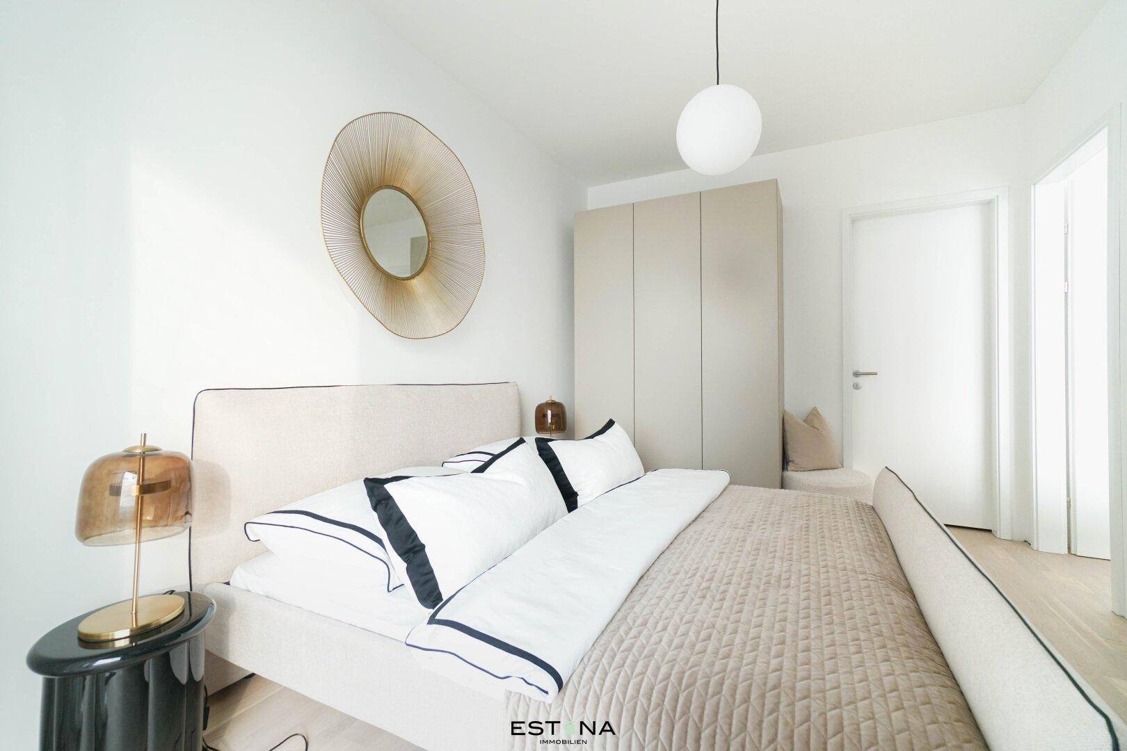 Helles Schlafzimmer mit komfortablem Bett, Nachttisch und modernem Kleiderschrank.