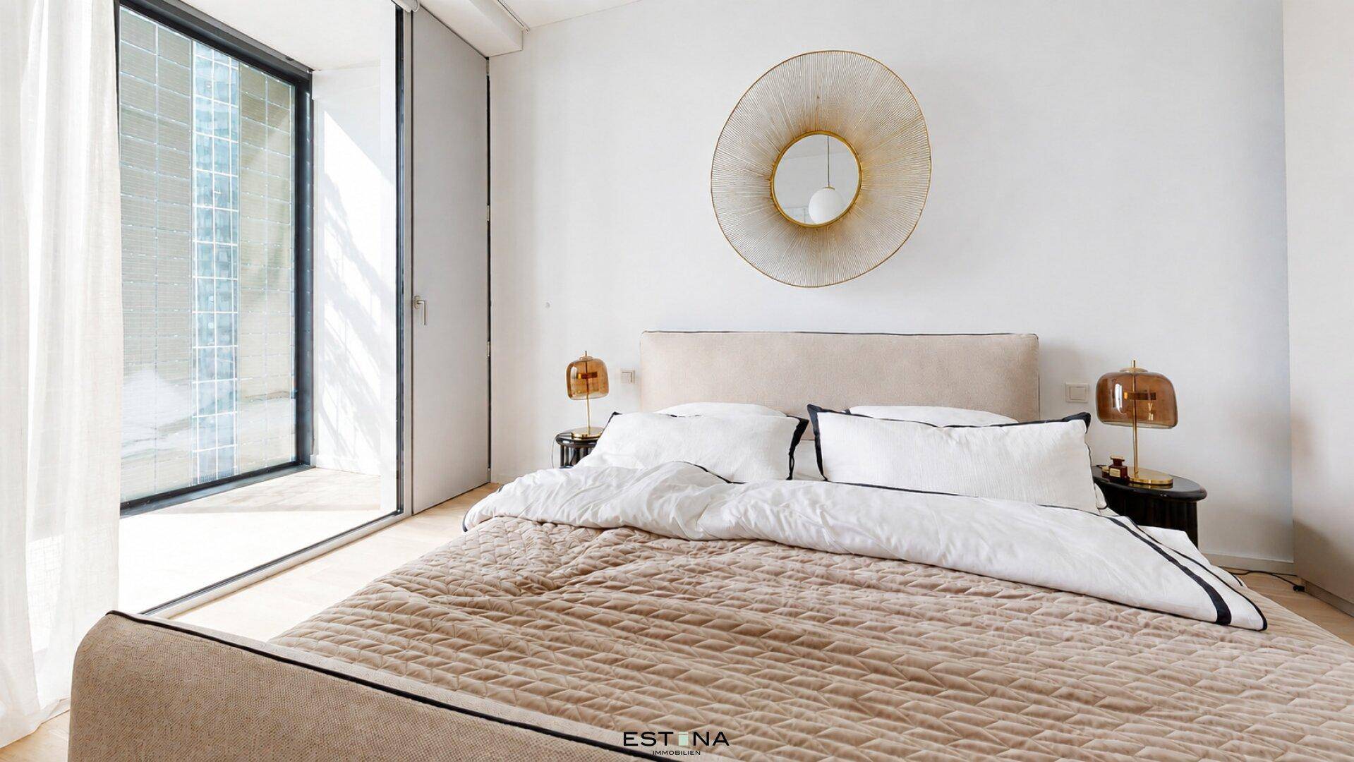 Gemütliches Schlafzimmer mit großem Fenster, das viel Tageslicht hereinlässt und modern eingerichtet ist.