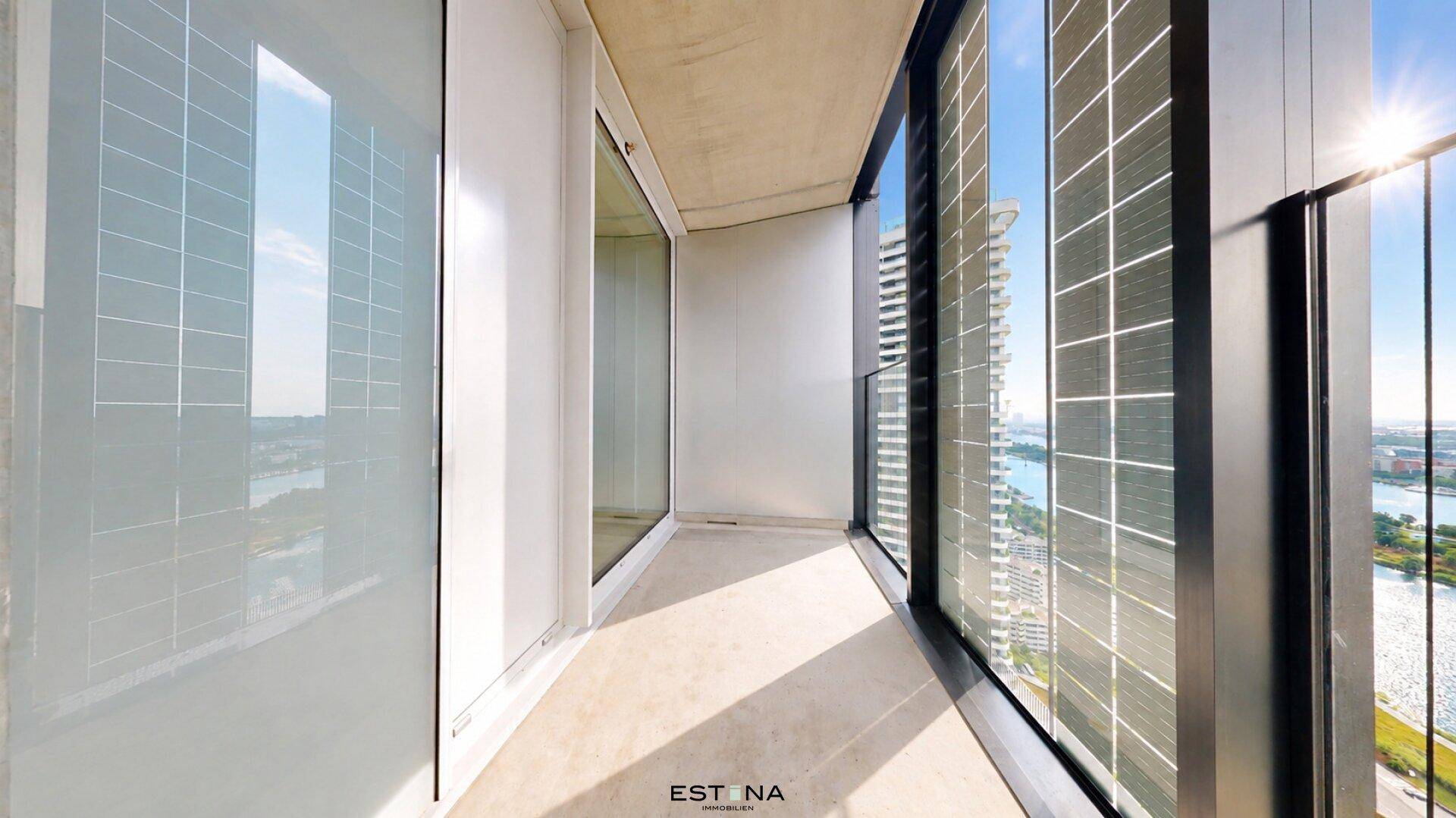 Geräumiger Balkon mit moderner Verglasung und hellem Boden, bietet einen weiten Ausblick.