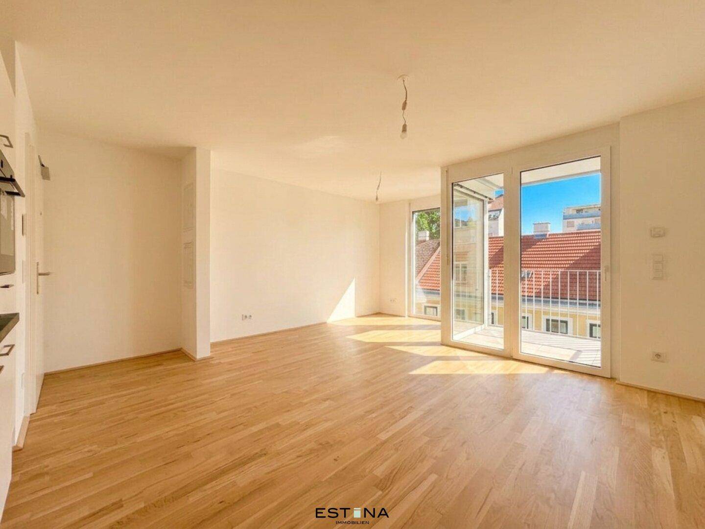 Lichtdurchfluteter Wohnbereich mit Parkettboden und Blick auf die umliegenden Gebäude.