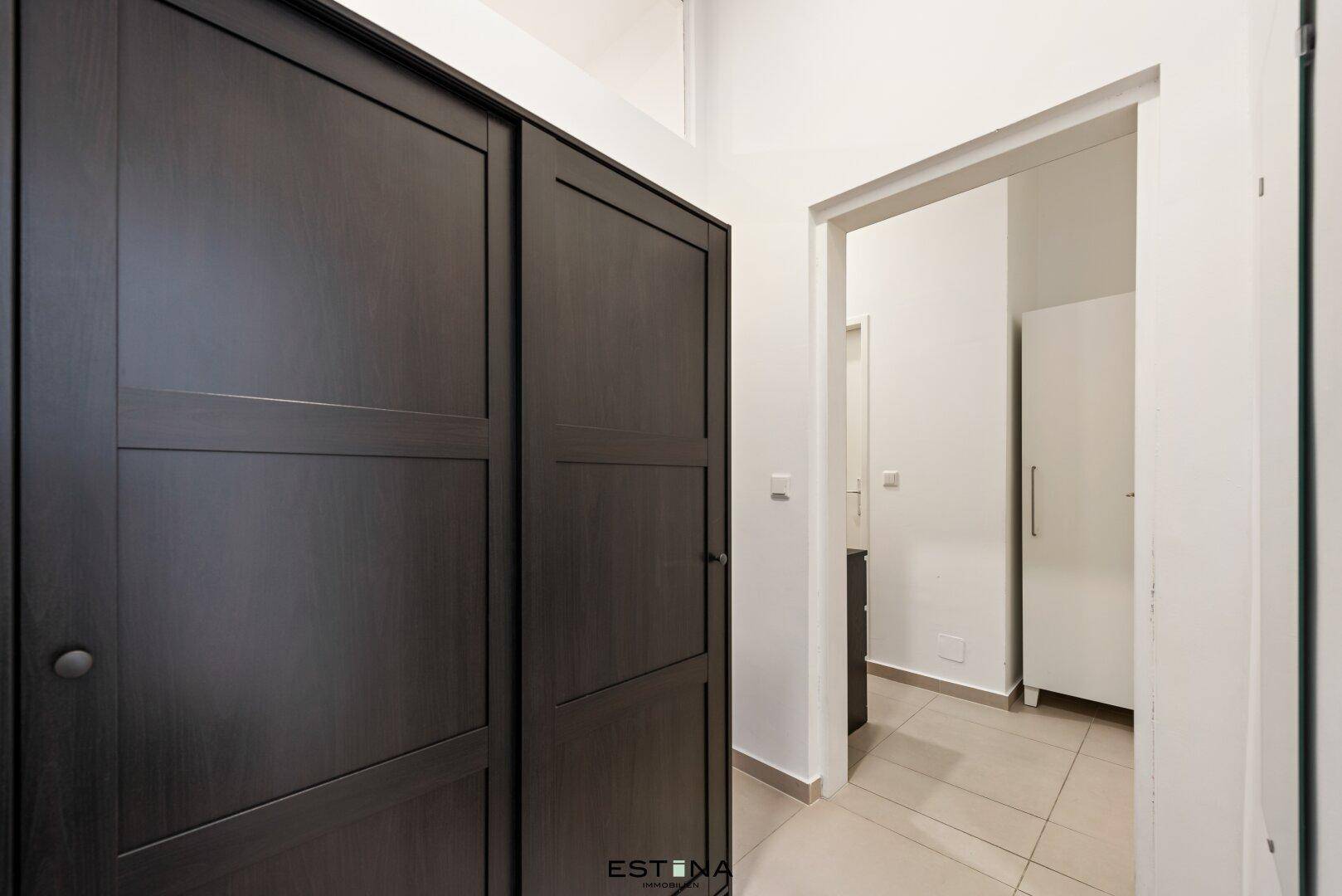 Heller Flur mit großem Einbauschrank und Fliesenboden, bietet viel Stauraum für Kleidung.