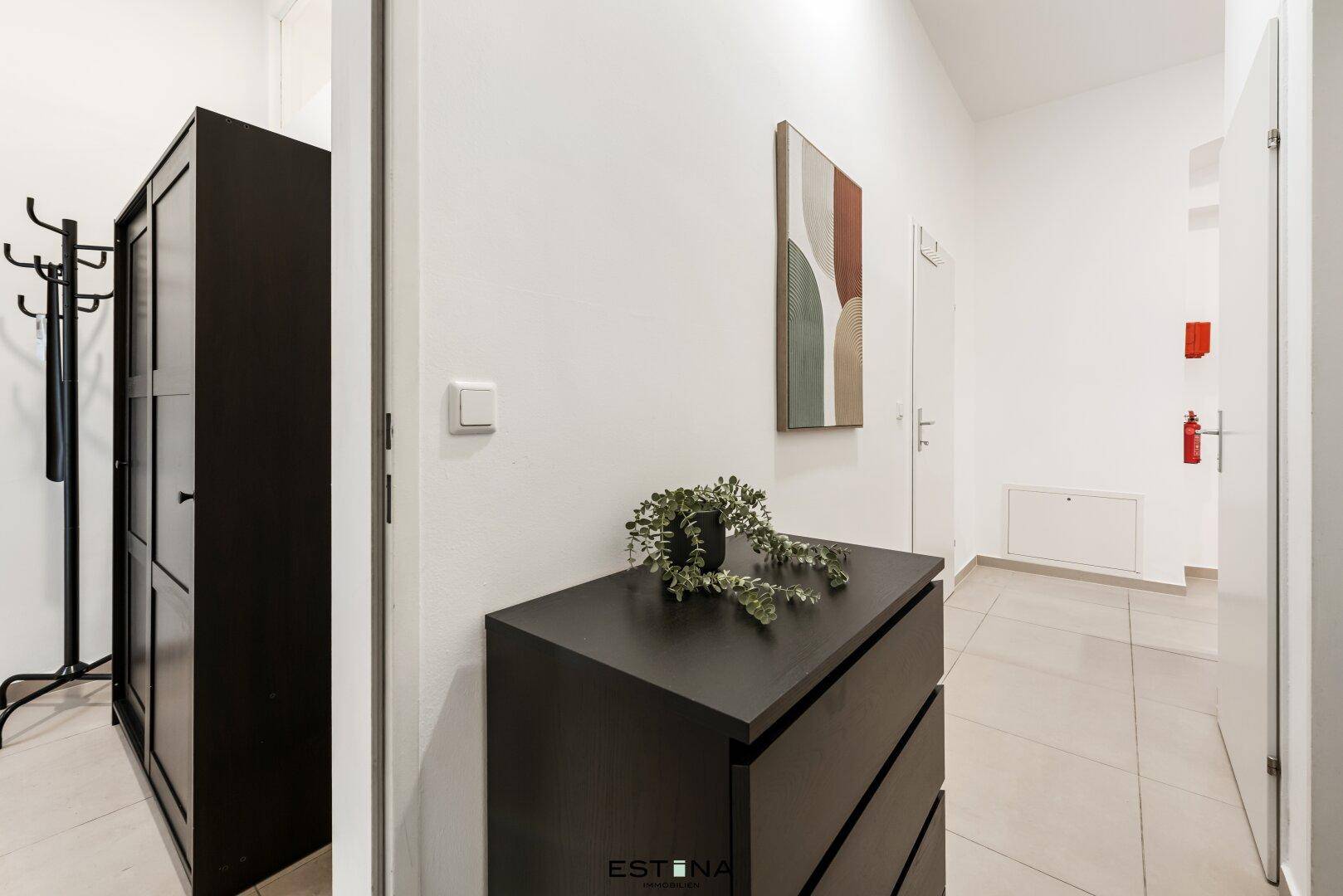 Heller Flur mit modernem Sideboard und Garderobe, bietet praktischen Stauraum beim Eingang.
