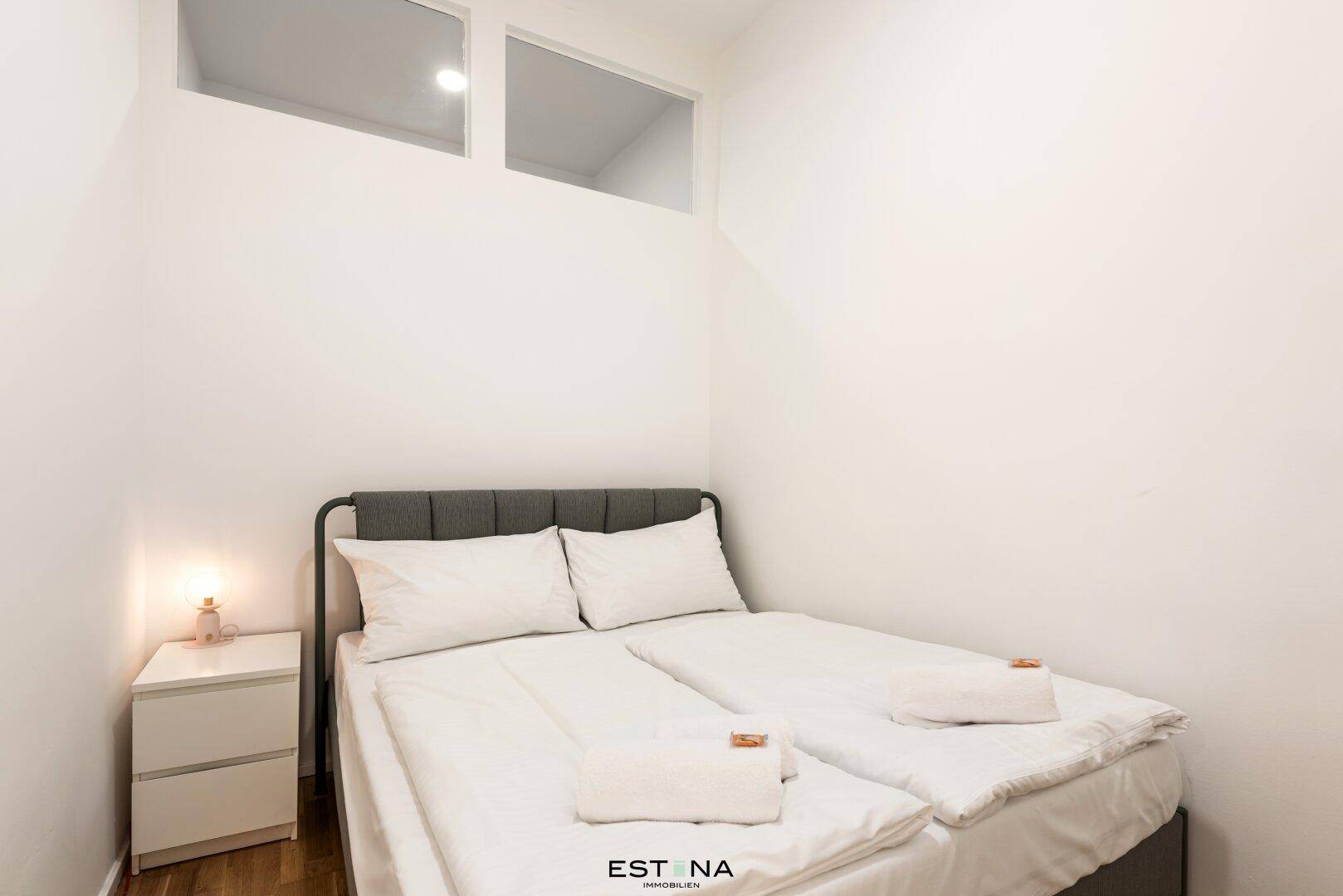 Gemütliches Schlafzimmer mit Doppelbett und Nachttisch, bietet einen ruhigen Rückzugsort.
