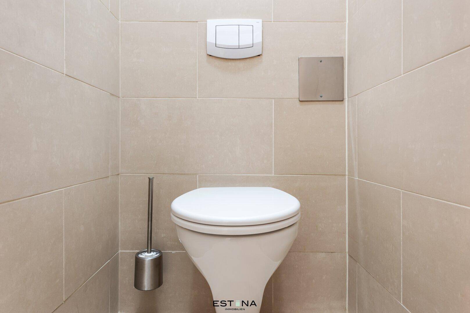 Modernes separates WC mit wandhängender Toilette und hellen Fliesen, sauber und funktional.