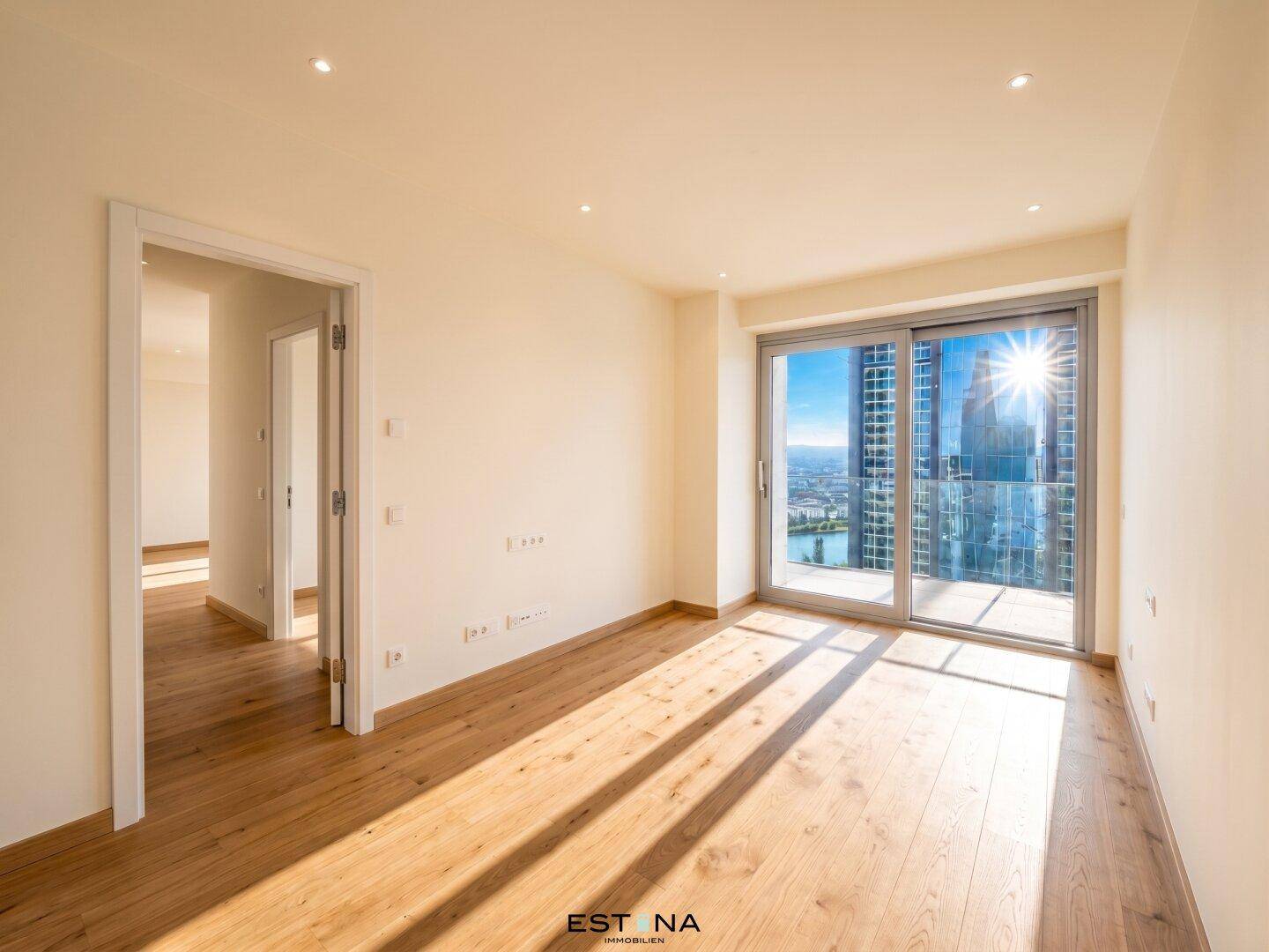 Helles Schlafzimmer mit Holzboden, großen Fenstern und weitem Blick über die Stadt und das Wasser.