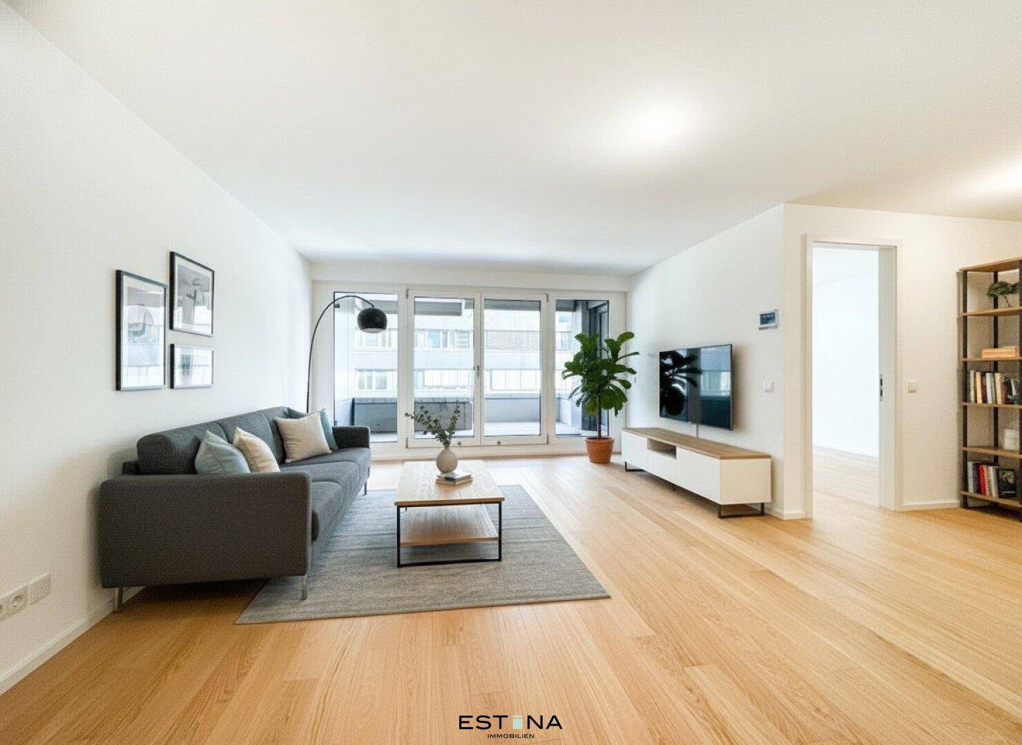 Helles Wohnzimmer mit modernem Sofa, Holzboden und Zugang zu einem Balkon.
