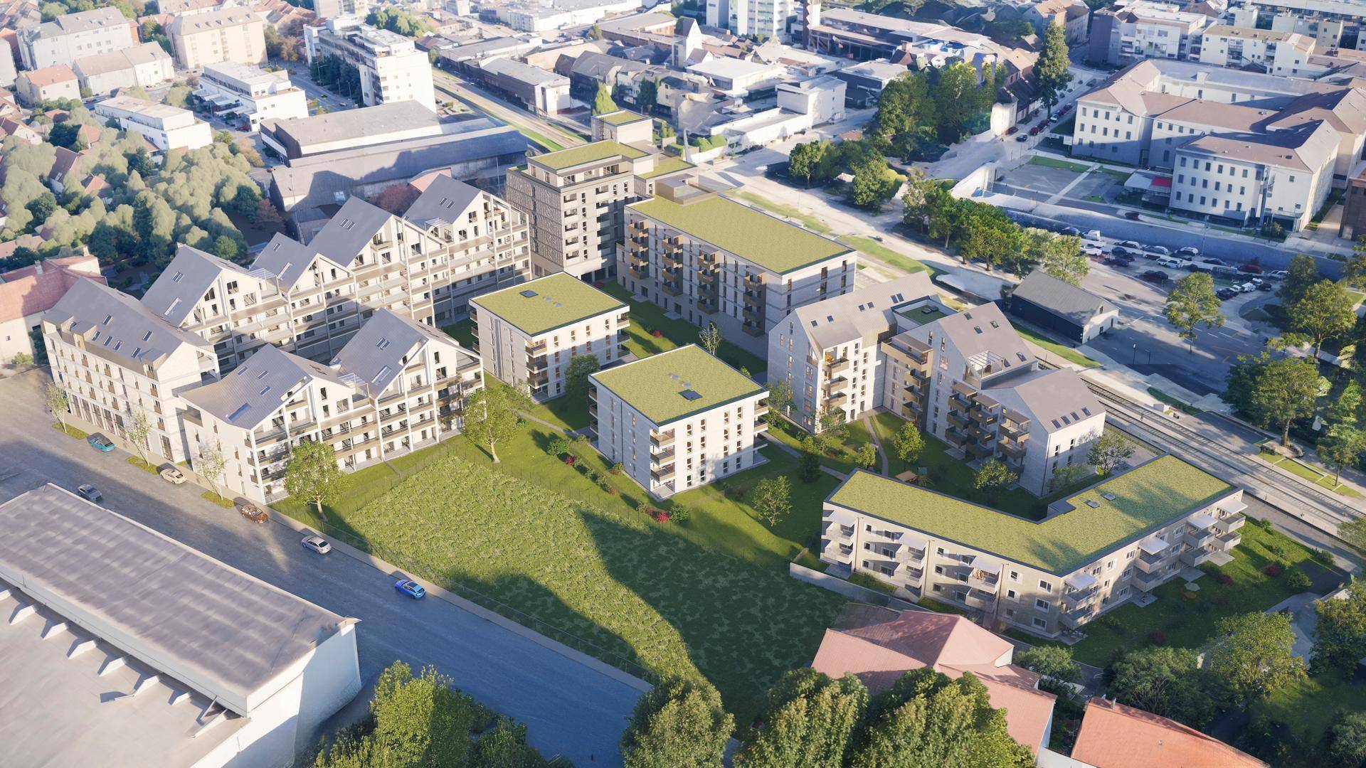 Weitläufige Luftaufnahme des neuen Wohnquartiers mit mehreren Gebäuden und Grünflächen in urbaner Umgebung.