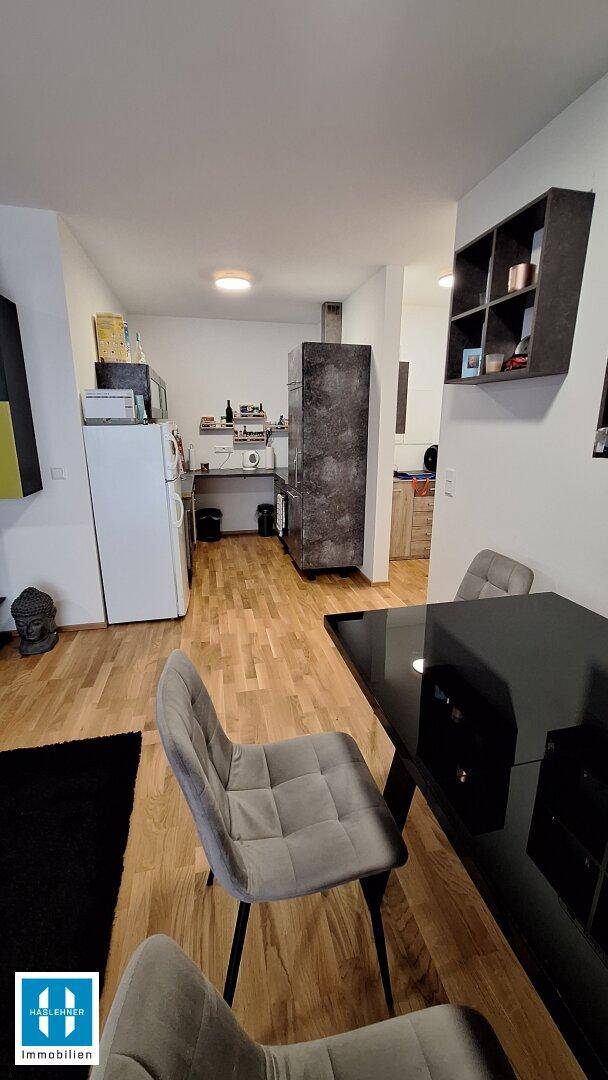 Offener Küchenbereich mit Kühlschrank und Arbeitsplatte, angrenzend an den Essbereich.