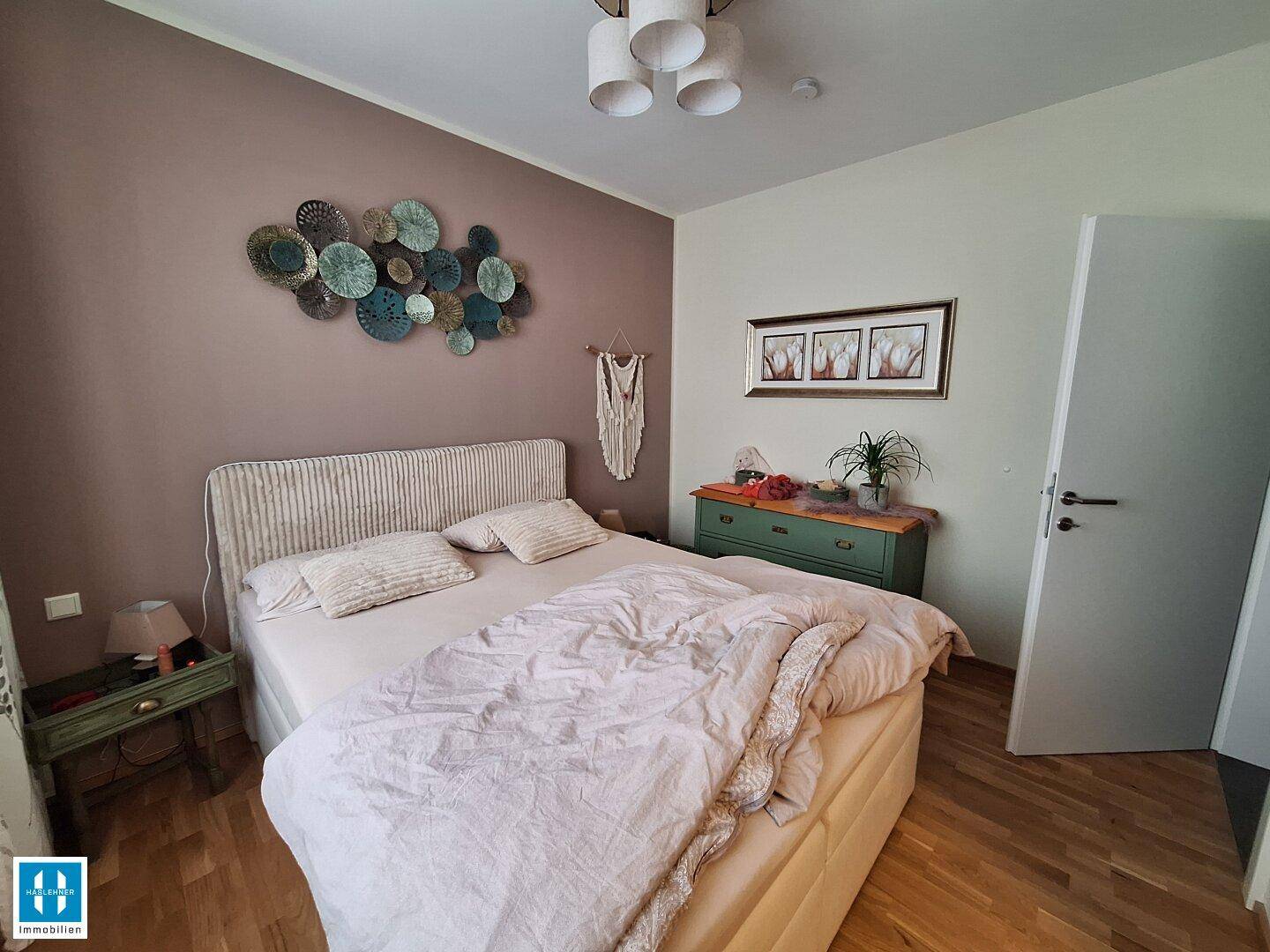Schlafzimmer mit Doppelbett, Nachttischen und einer dezenten Wanddekoration.
