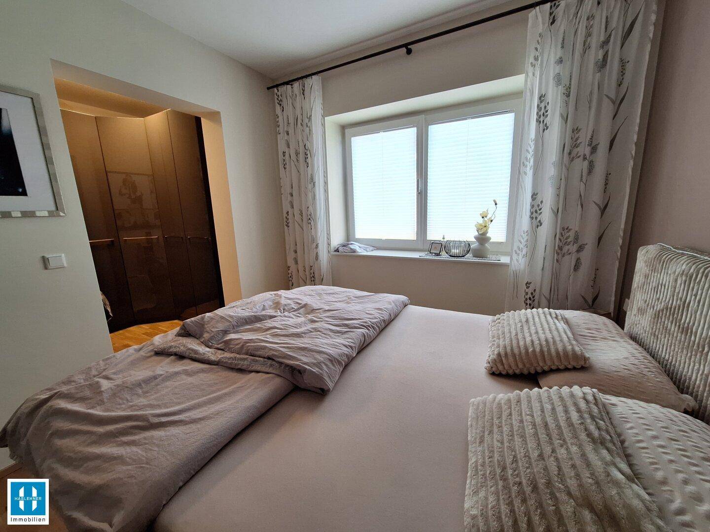 Schlafzimmer mit Doppelbett und integriertem Kleiderschrank, der viel Stauraum bietet.
