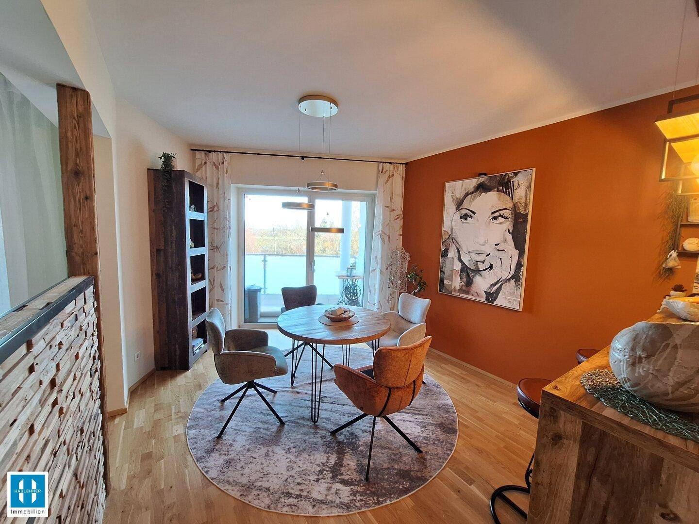 Gemütlicher Essbereich mit Holztisch, modernen Stühlen und Blick auf den Balkon.