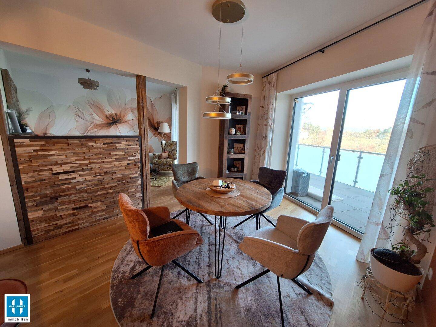 Heller Essbereich mit Holztisch, modernen Stühlen und Zugang zu einem großen Balkon.