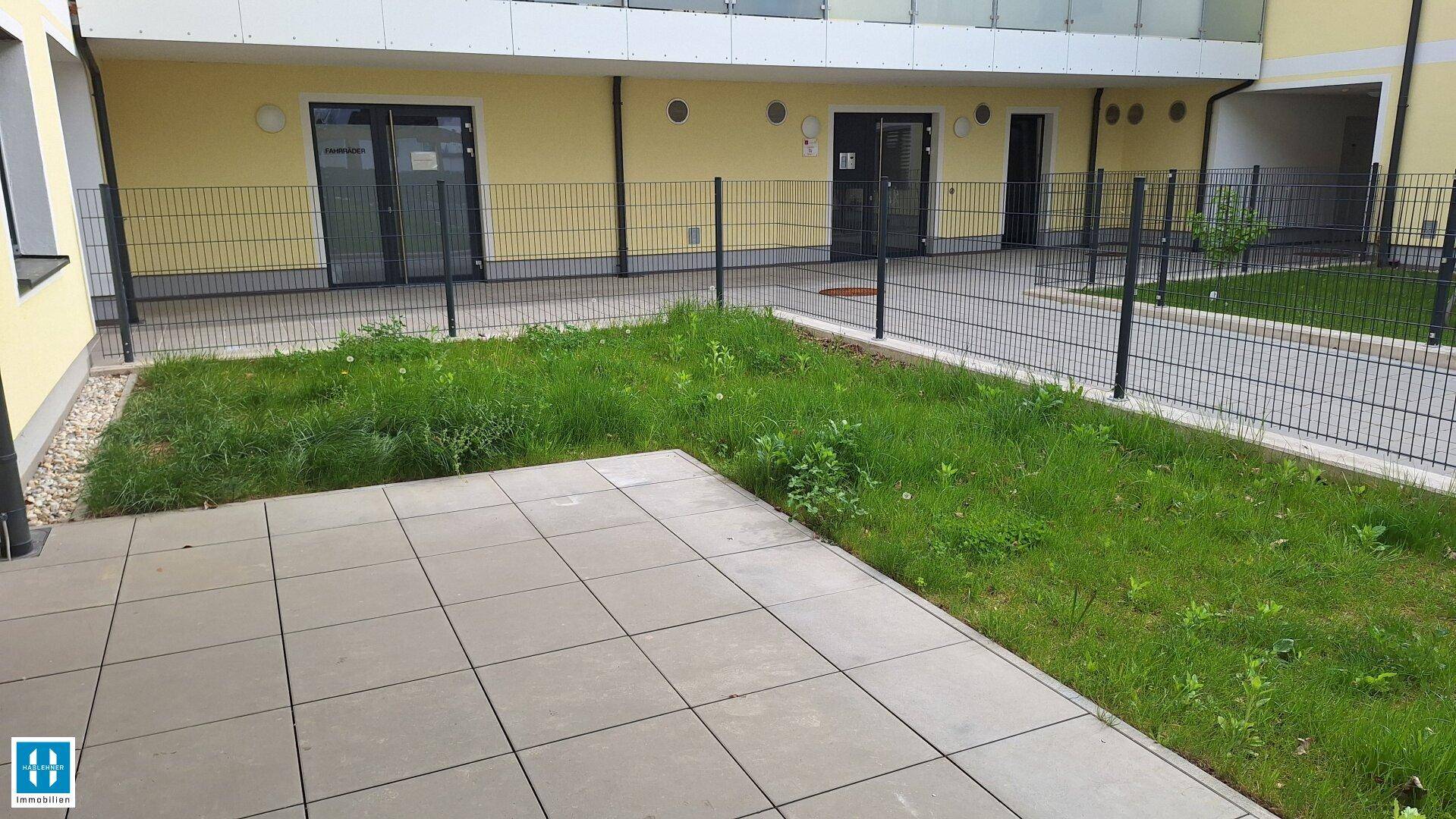 Erdgeschoss-Terrasse mit angrenzendem Gartenbereich, ideal für Entspannung im Freien.