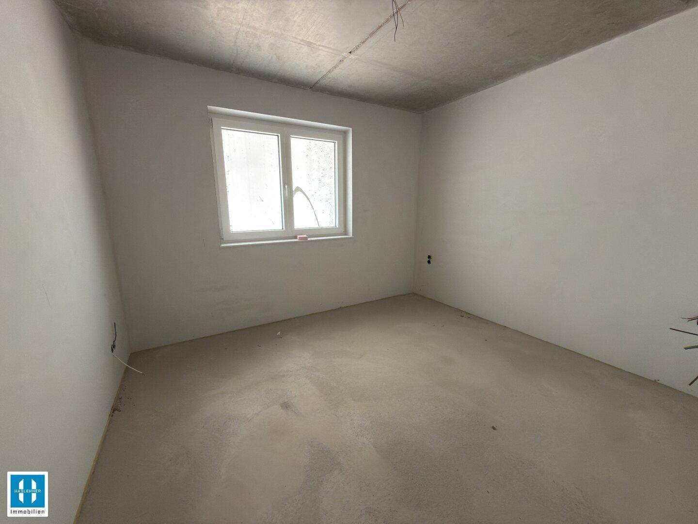 Kleinerer Rohbau-Raum mit einem Fenster, ideal als zukünftiges Schlaf- oder Arbeitszimmer.