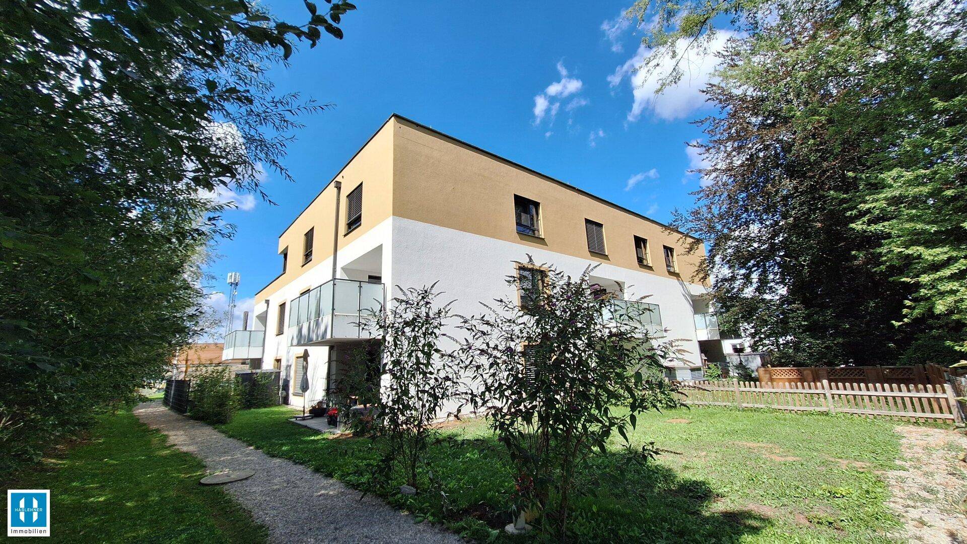 Moderne Wohnanlage mit gepflegter Grünfläche und Bäumen in ruhiger Lage.