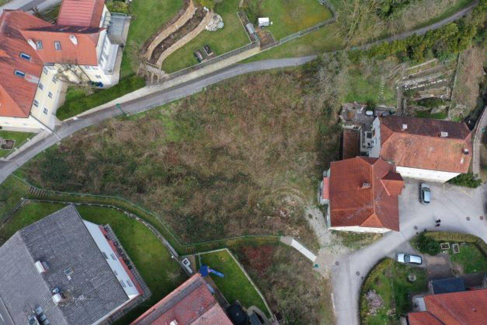 Weitläufige Luftaufnahme des Anwesens mit umliegenden Gebäuden und viel Natur.
