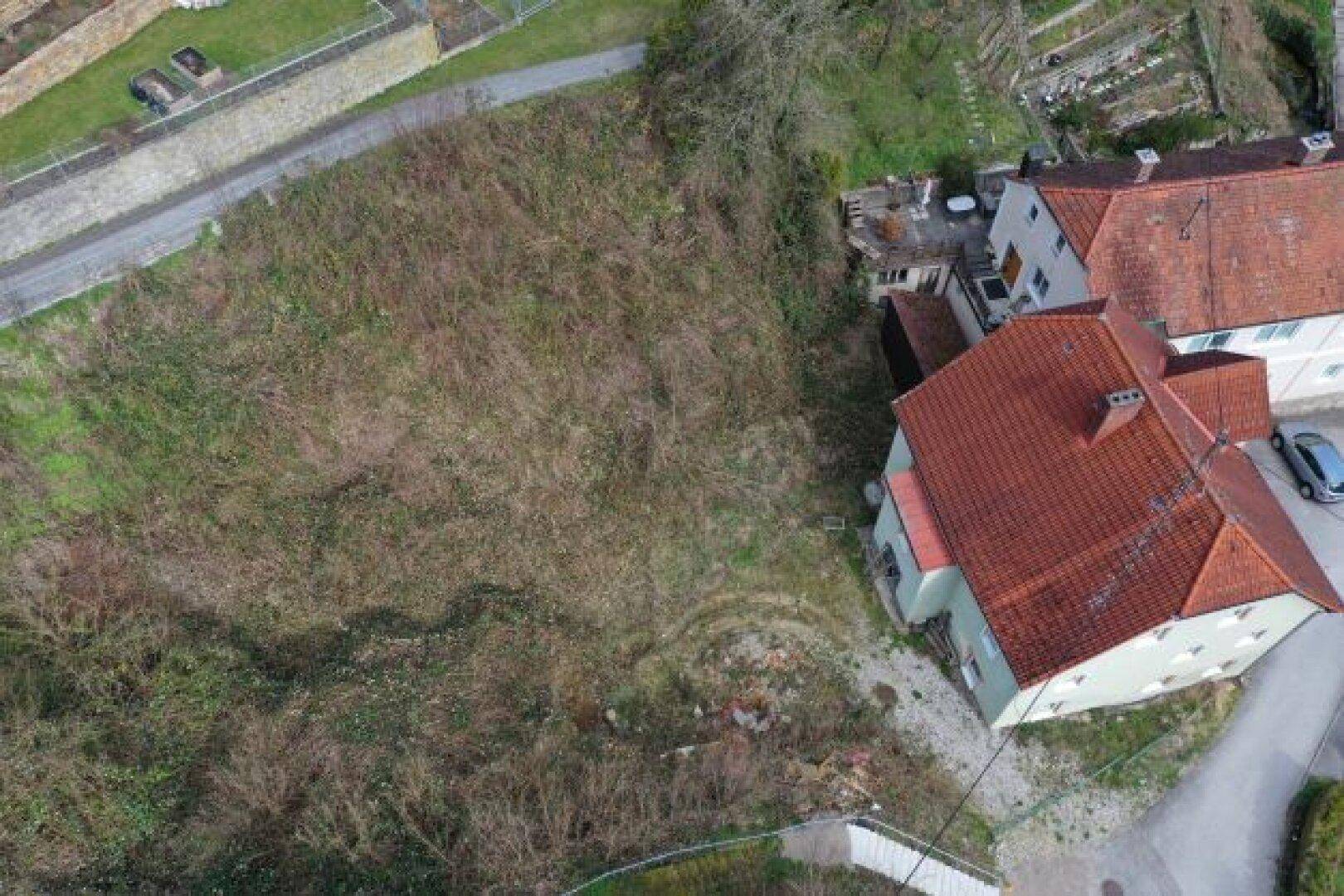 Luftaufnahme des Grundstücks mit angrenzendem Gebäude und viel Grünfläche.