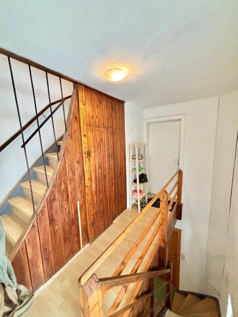 Treppenhaus mit Holzverkleidung und Geländer, das die verschiedenen Etagen verbindet.