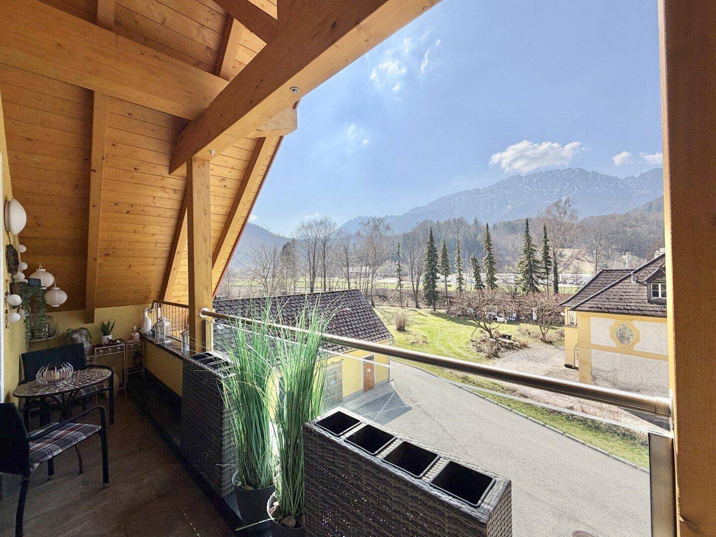 Geräumiger Balkon mit Holzdach und atemberaubendem Blick auf die grüne Berglandschaft.