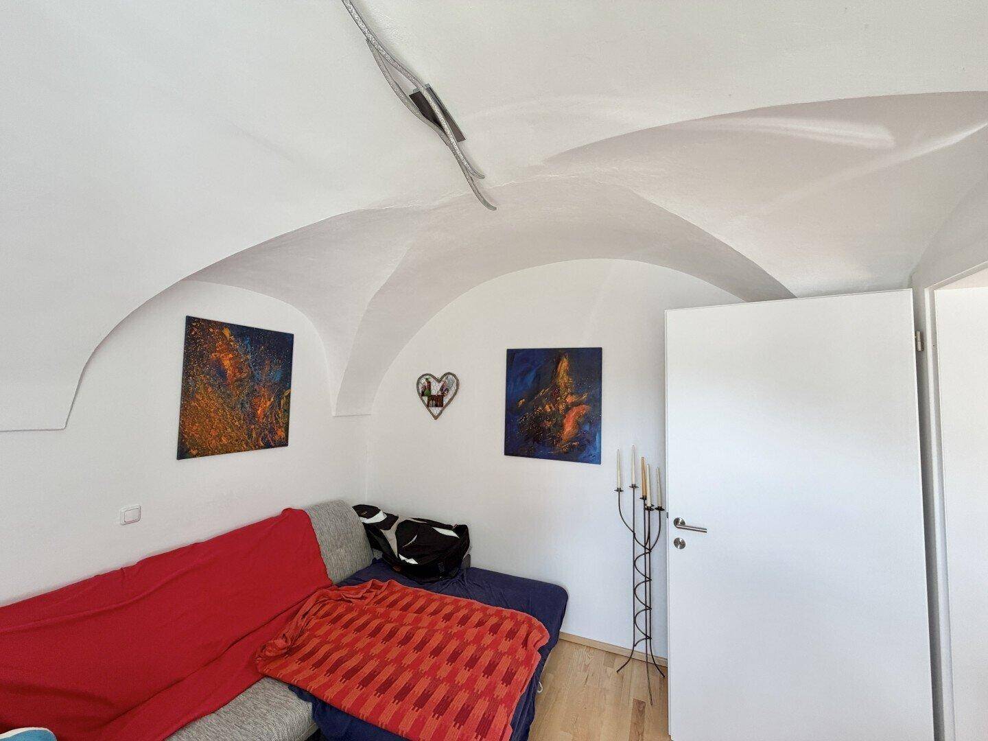 Raum mit einzigartiger Gewölbedecke und minimalistischer Einrichtung, ideal als Wohn- oder Schlafbereich.