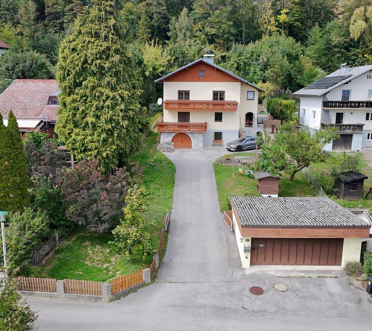 Luftaufnahme des Hauses mit separater Garage, umgeben von Bäumen und ländlicher Umgebung.