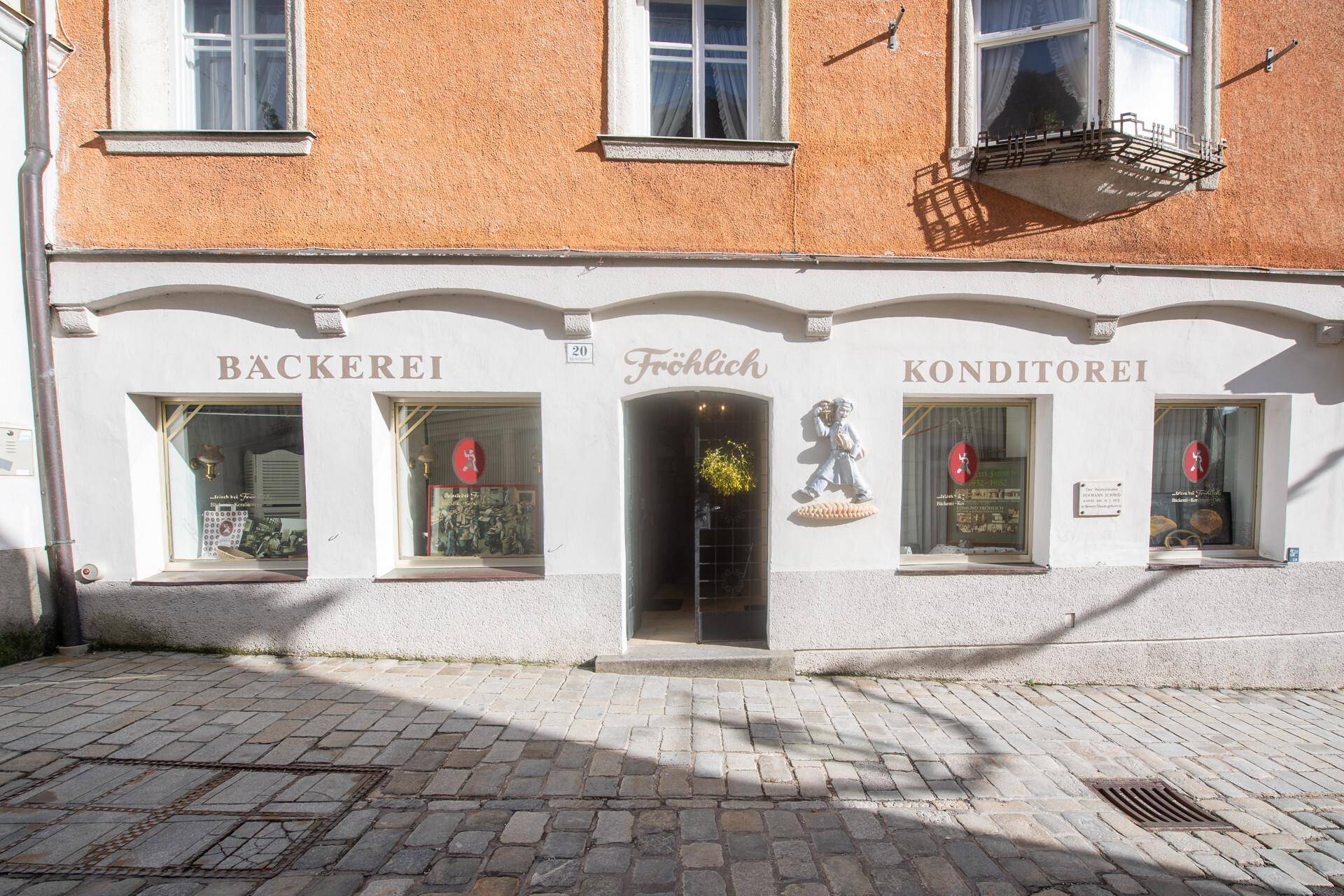 Erdgeschossfassade eines historischen Gebäudes mit Schaufenstern einer Bäckerei und Konditorei.