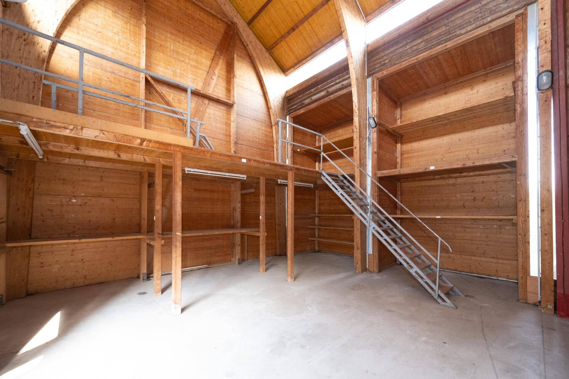 Große Halle mit hohen Holzdecken, Galerie und Betonboden, ideal als Werkstatt oder Lager.