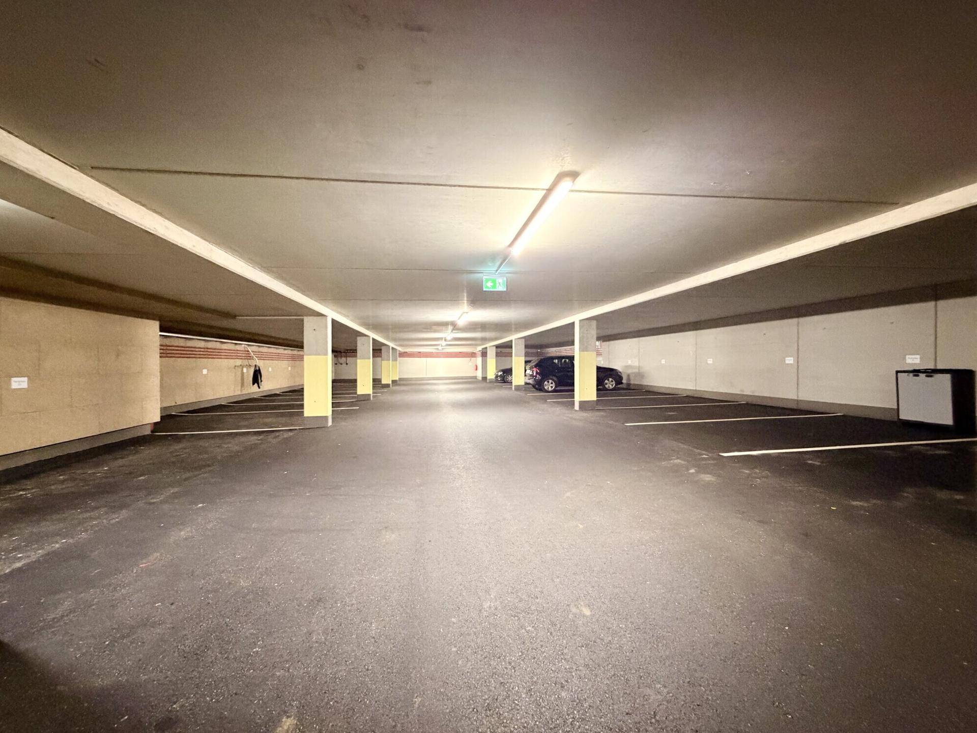 Geräumige Tiefgarage mit vielen Stellplätzen und guter Beleuchtung, bietet sicheres Parken.