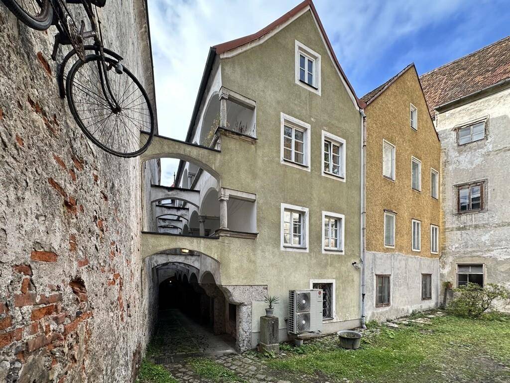 Historische Gebäude mit einem Durchgang und einem Innenhof, der eine ruhige Atmosphäre bietet.