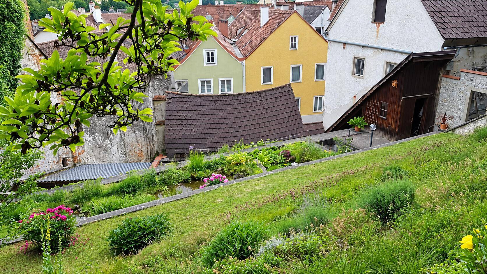 Malerischer Blick auf die Altstadt mit historischen Gebäuden und grünen Hängen.