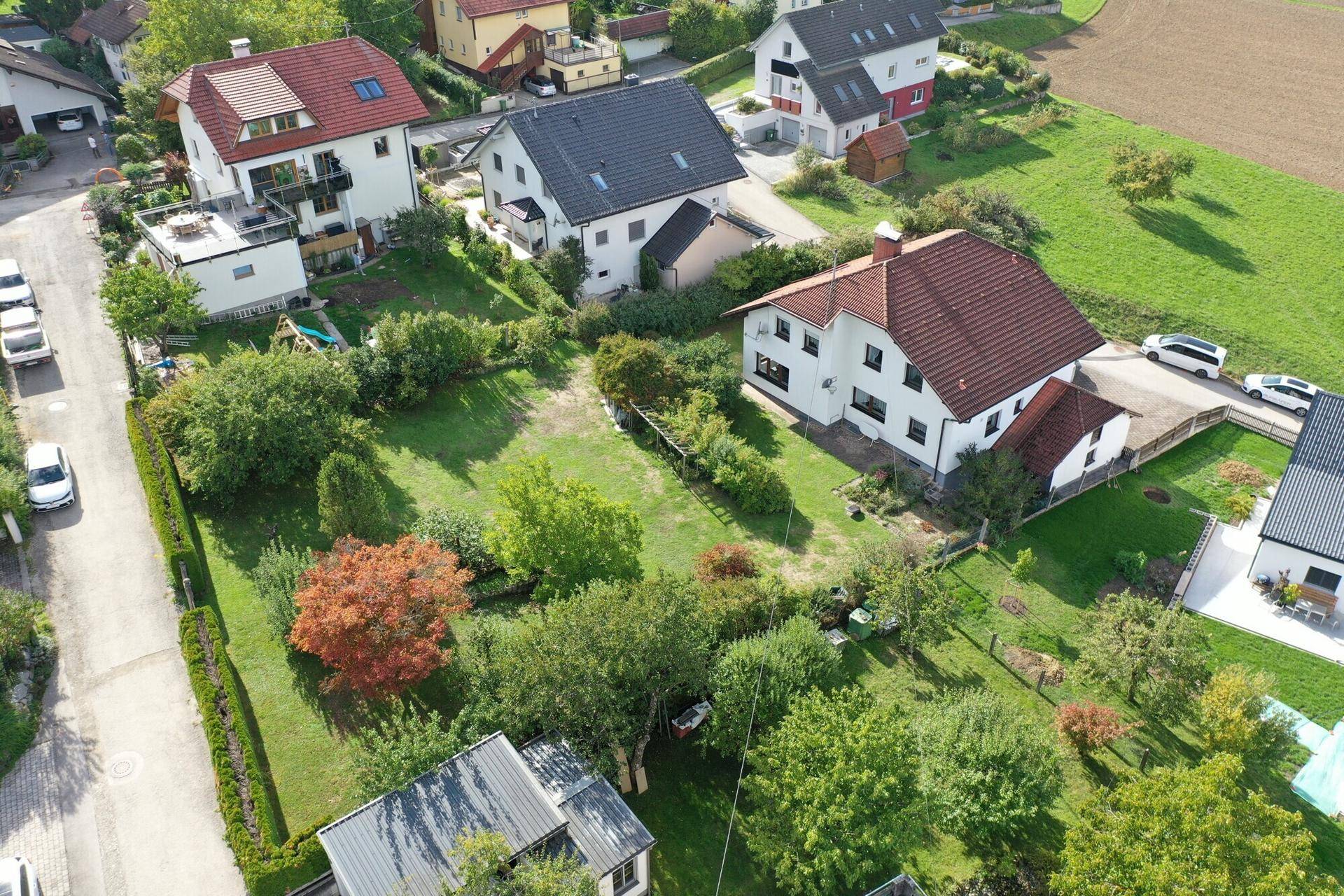 Weitläufige Luftaufnahme des Grundstücks mit großem Rasenbereich und angrenzenden Feldern.