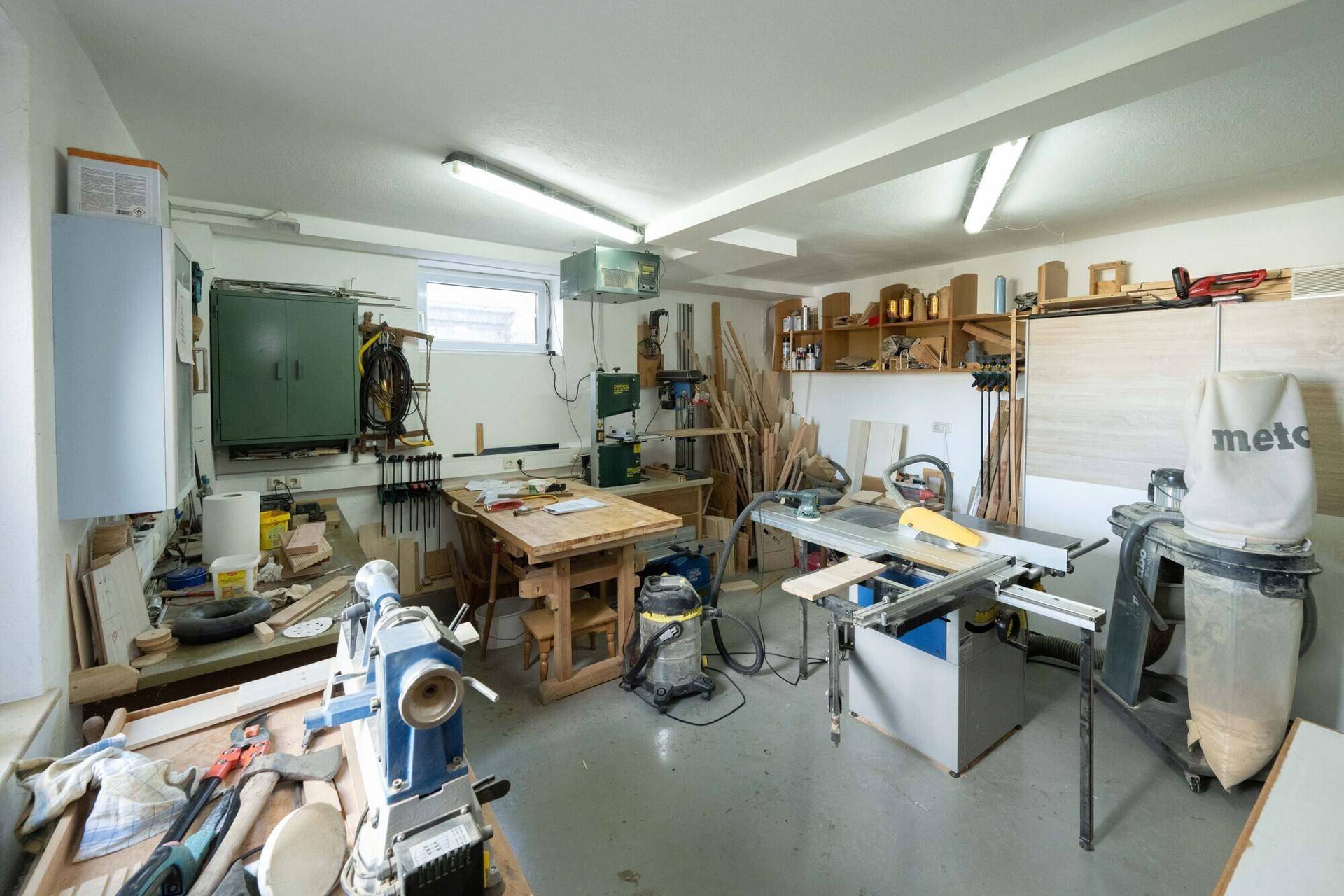 Gut ausgestattete Werkstatt mit verschiedenen Maschinen und Arbeitsflächen.