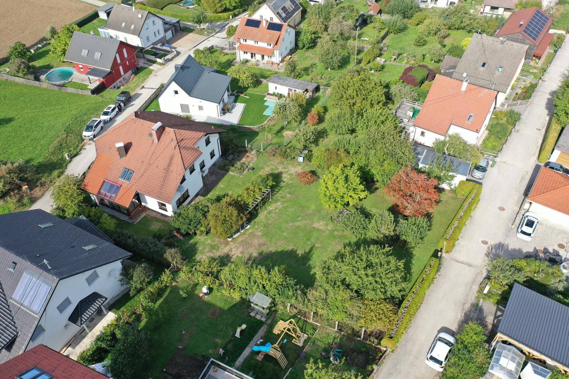 Weitläufige Luftaufnahme des Grundstücks mit großem Garten und angrenzender Wohnsiedlung.