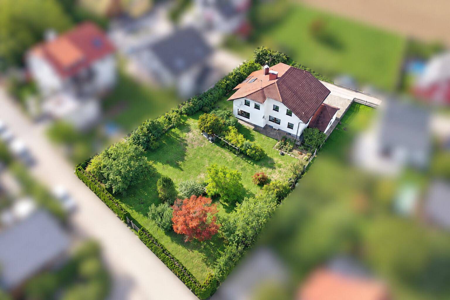 Übersichtliche Luftaufnahme des Anwesens mit einem Einfamilienhaus und weitläufigem, grünen Garten.