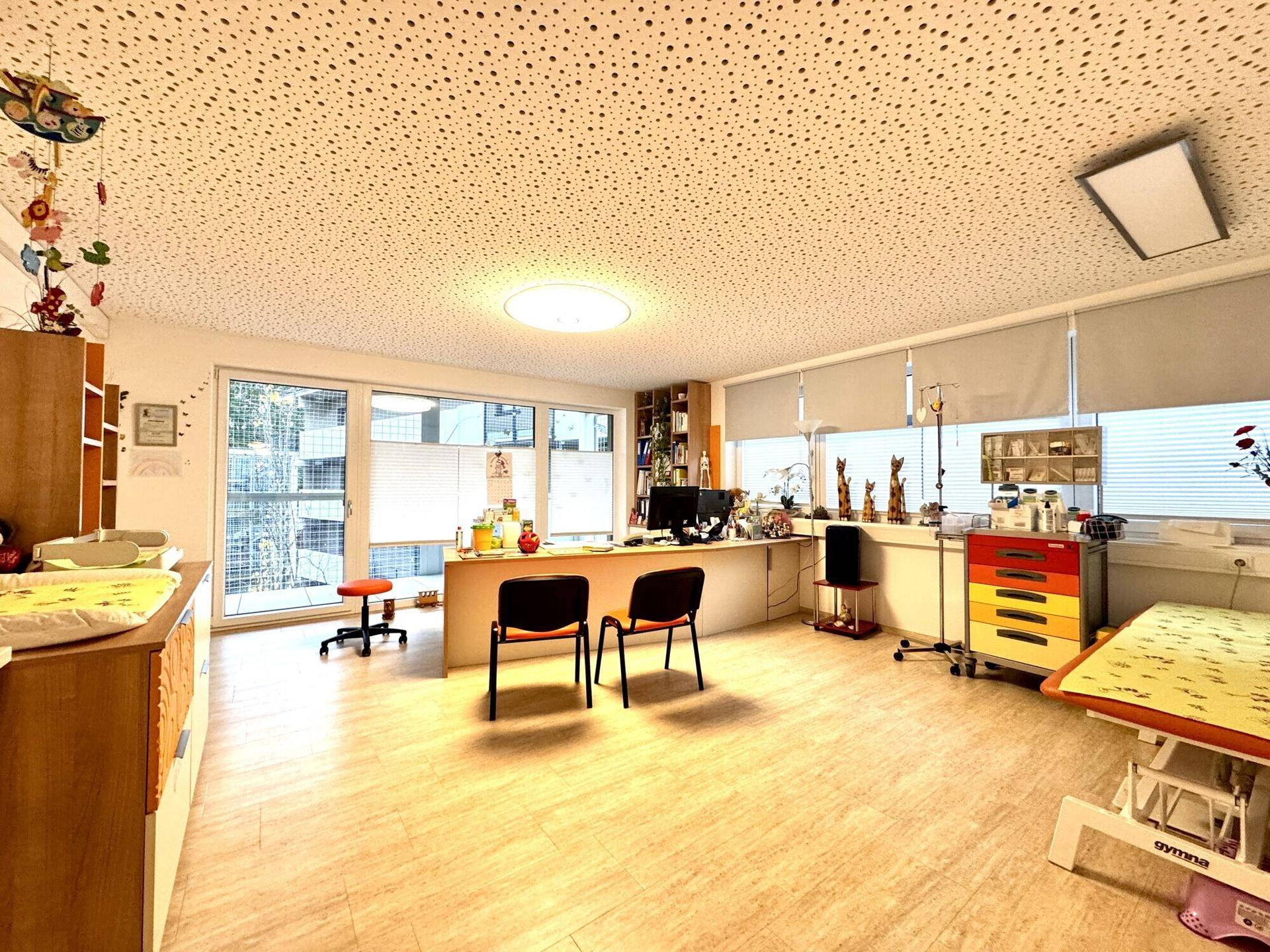 Großes Büro oder Behandlungszimmer mit mehreren Arbeitsbereichen, Schreibtischen und viel Stauraum.