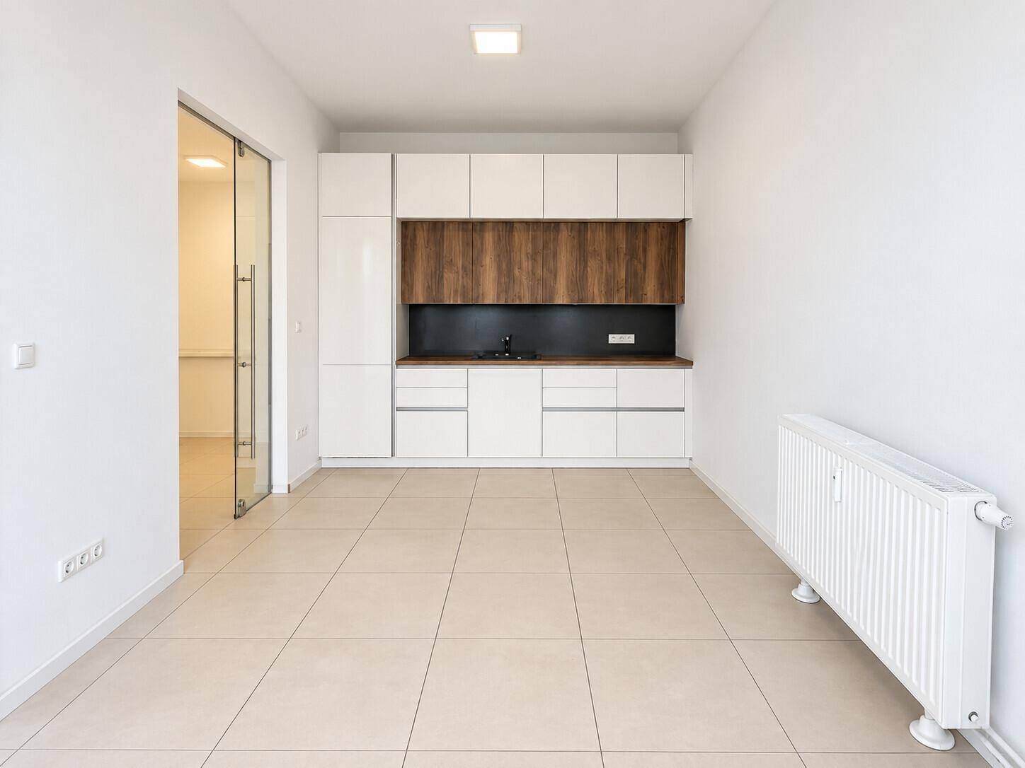 Moderne Küchenzeile mit weißen Hochglanzschränken und Holzdetails in einem hellen Raum.