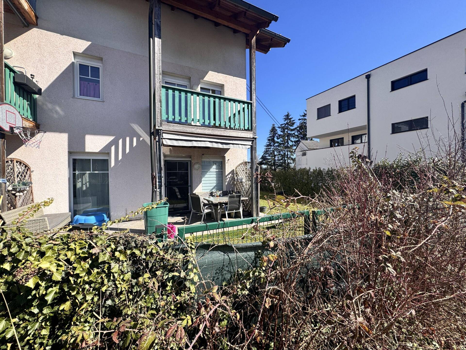 Terrasse im Erdgeschoss mit Gartenmöbeln und Blick auf die Nachbarschaft.
