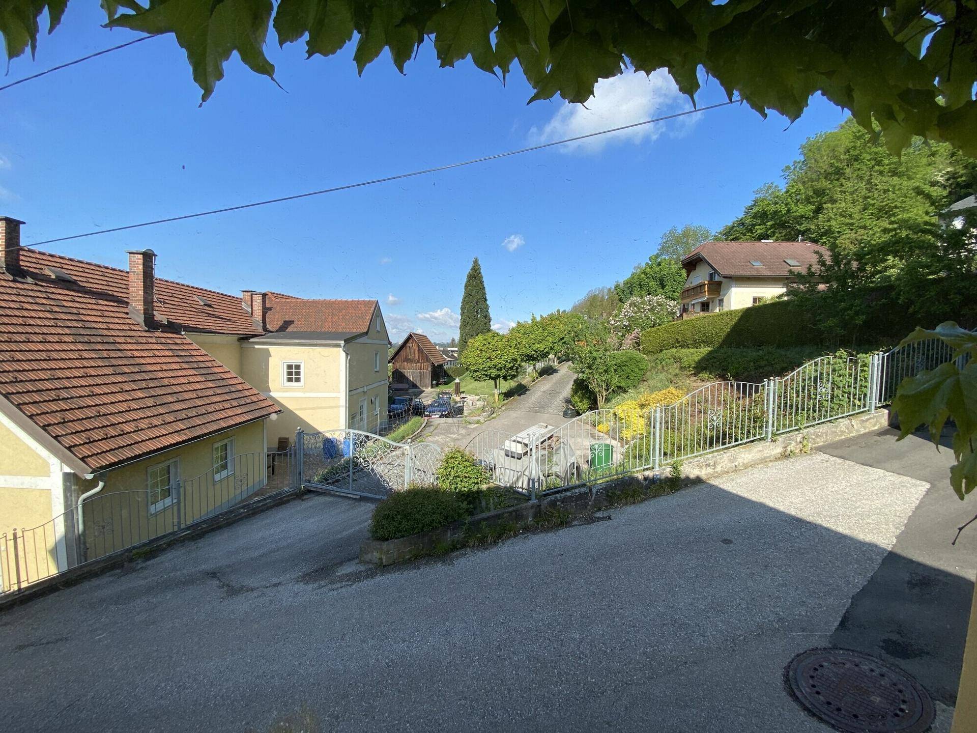 Blick auf die ländliche Umgebung mit Häusern, Bäumen und einer Straße.
