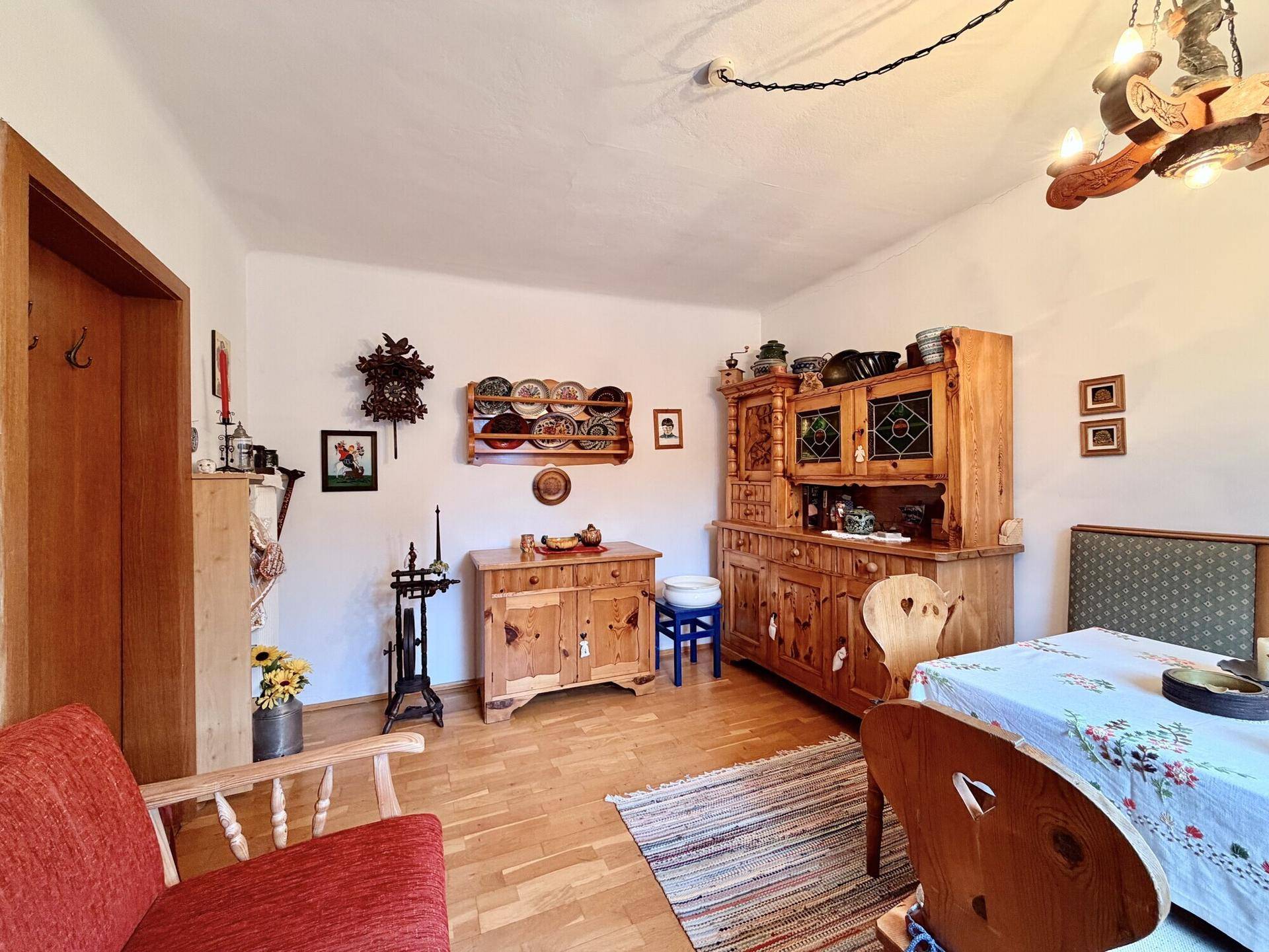 Traditioneller Wohnbereich mit rustikalen Holzmöbeln, Teppich und hellem Holzboden.