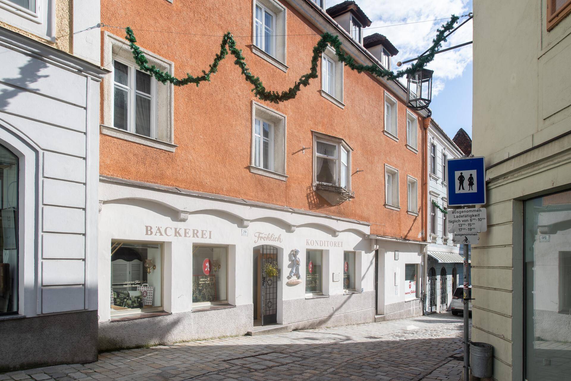Detailansicht einer historischen Gebäudefassade mit Bäckerei und Konditorei im Erdgeschoss.