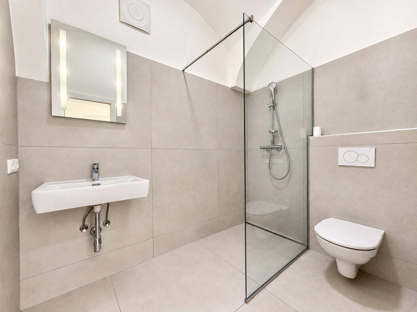 Modernes Badezimmer mit begehbarer Dusche, Wand-WC und eleganten Fliesen.