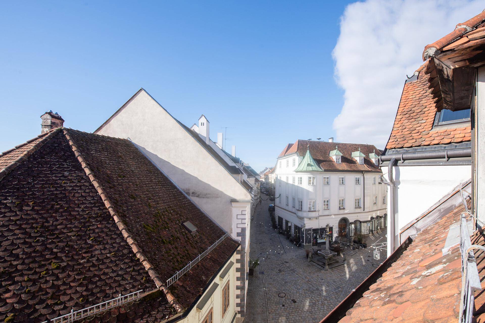 Weite Aussicht über die Dächer der Altstadt mit belebter Straße und historischer Architektur.