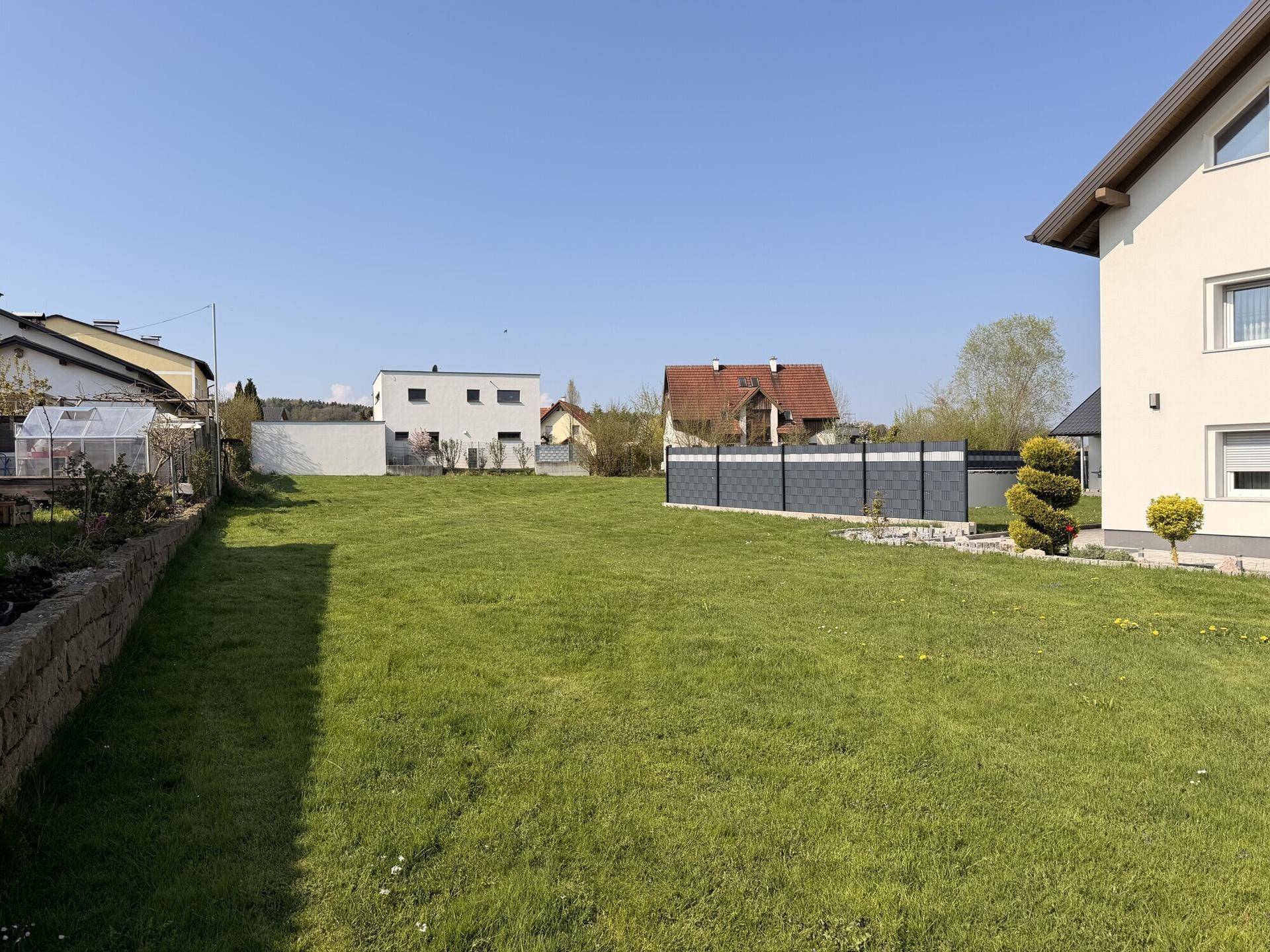 Großes, offenes Grundstück mit Rasen und Blick auf die umliegende Wohnbebauung.