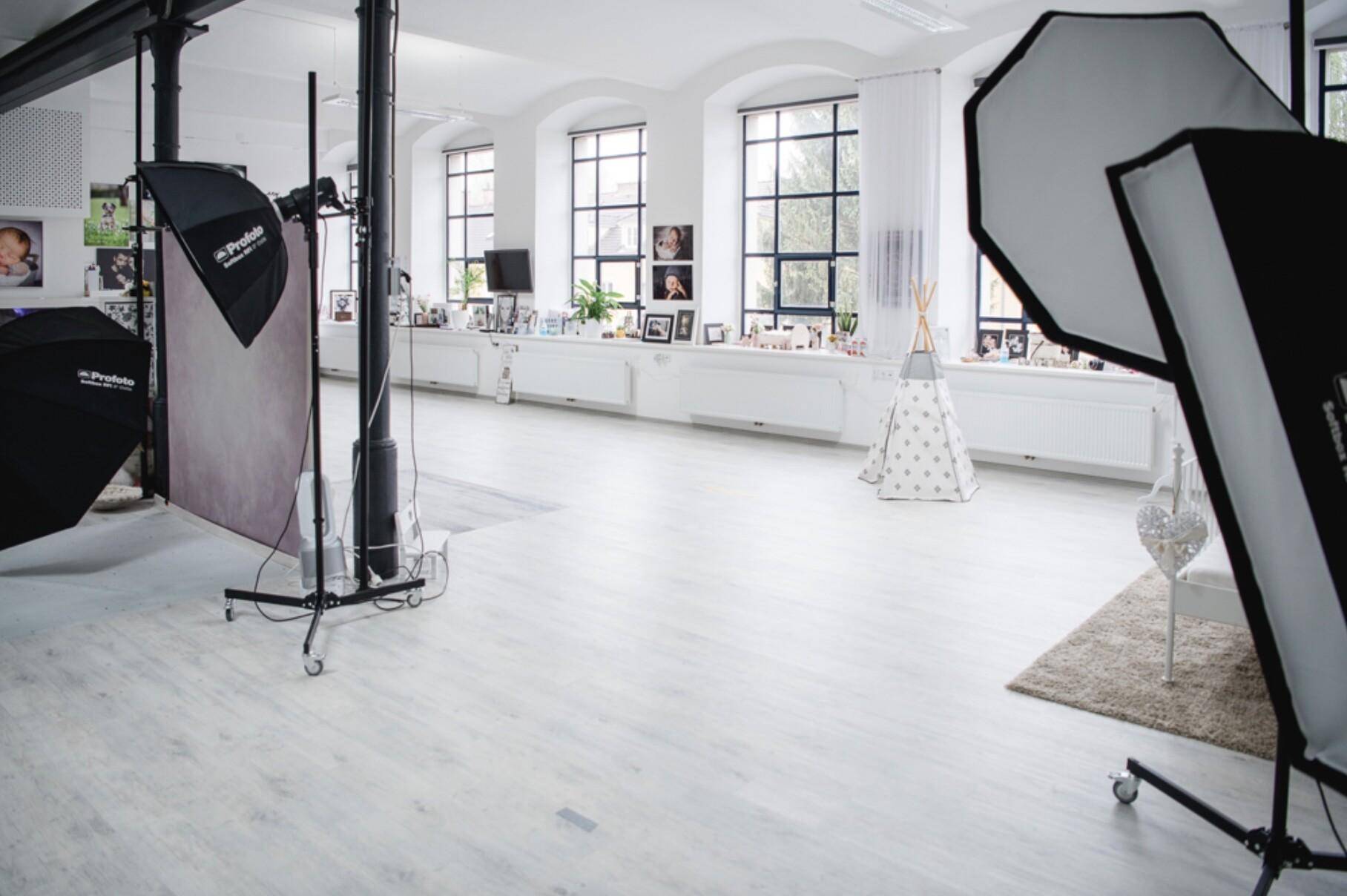 Offener, heller Raum mit großen Fenstern, hohen Decken und professioneller Fotoausrüstung.