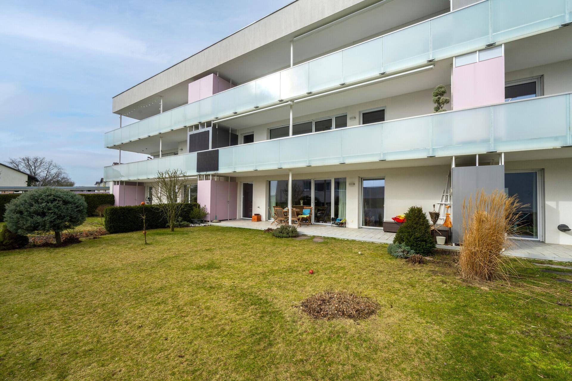 Gepflegter Gartenbereich mit Rasenfläche und direktem Zugang zu den Terrassen der Erdgeschosswohnungen.